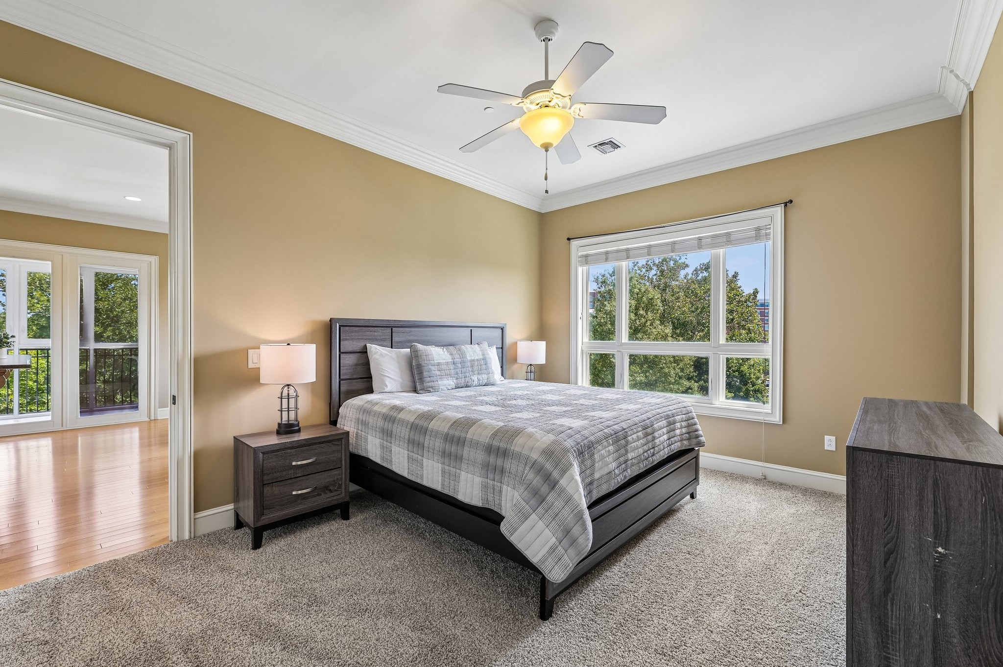 Bedroom at The Gateway Village apartments for rent, featuring a classic wooden sleigh bed, matching furniture, and a large window with natural light.