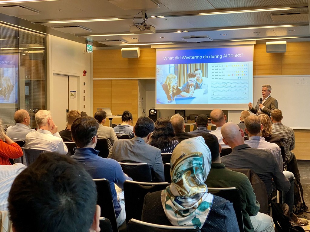 Behind-the-scenes view of a video production team preparing a speaker in a studio with cameras and lighting equipment