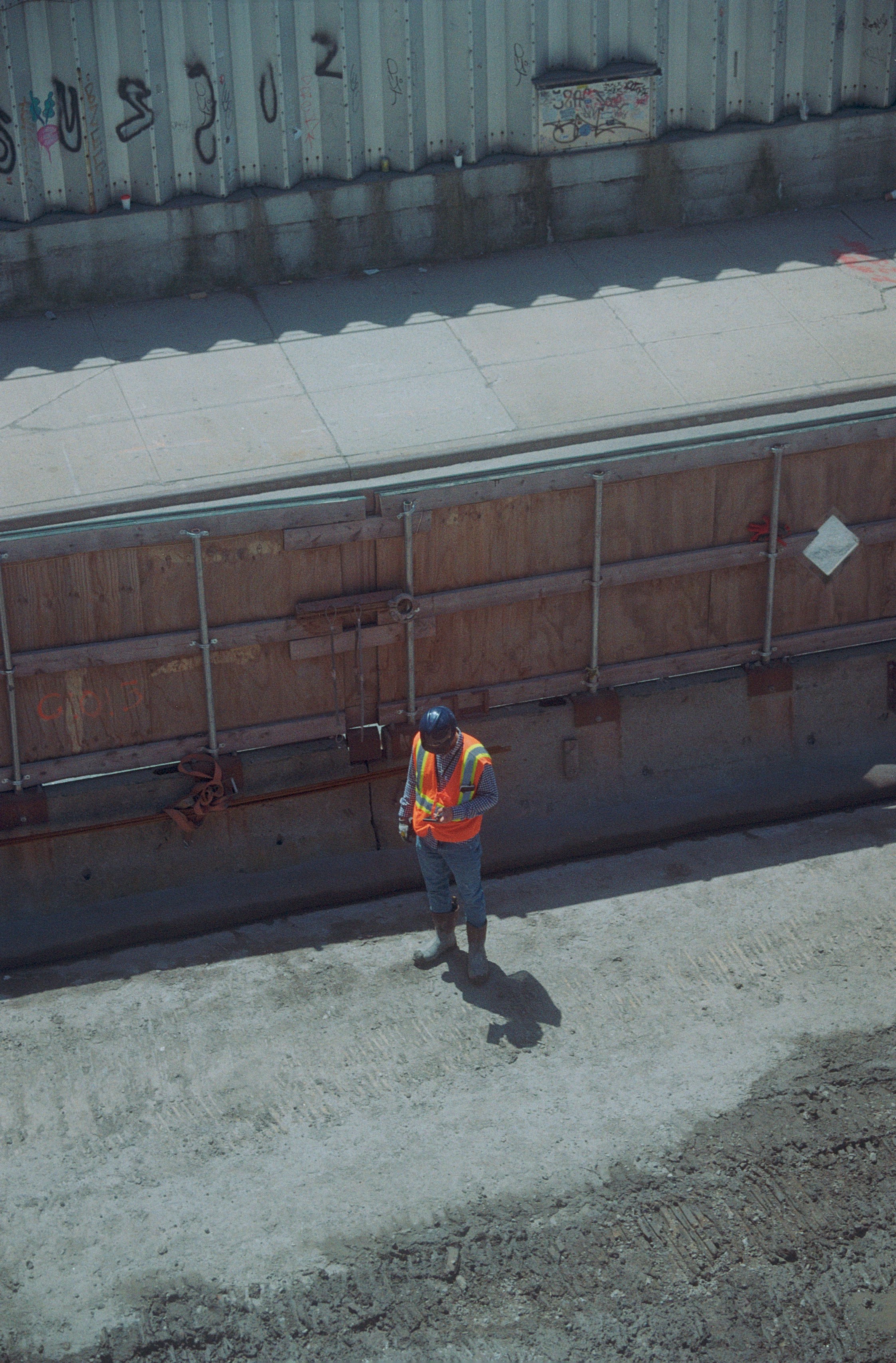 Construction worker in safety vest stands on dirt