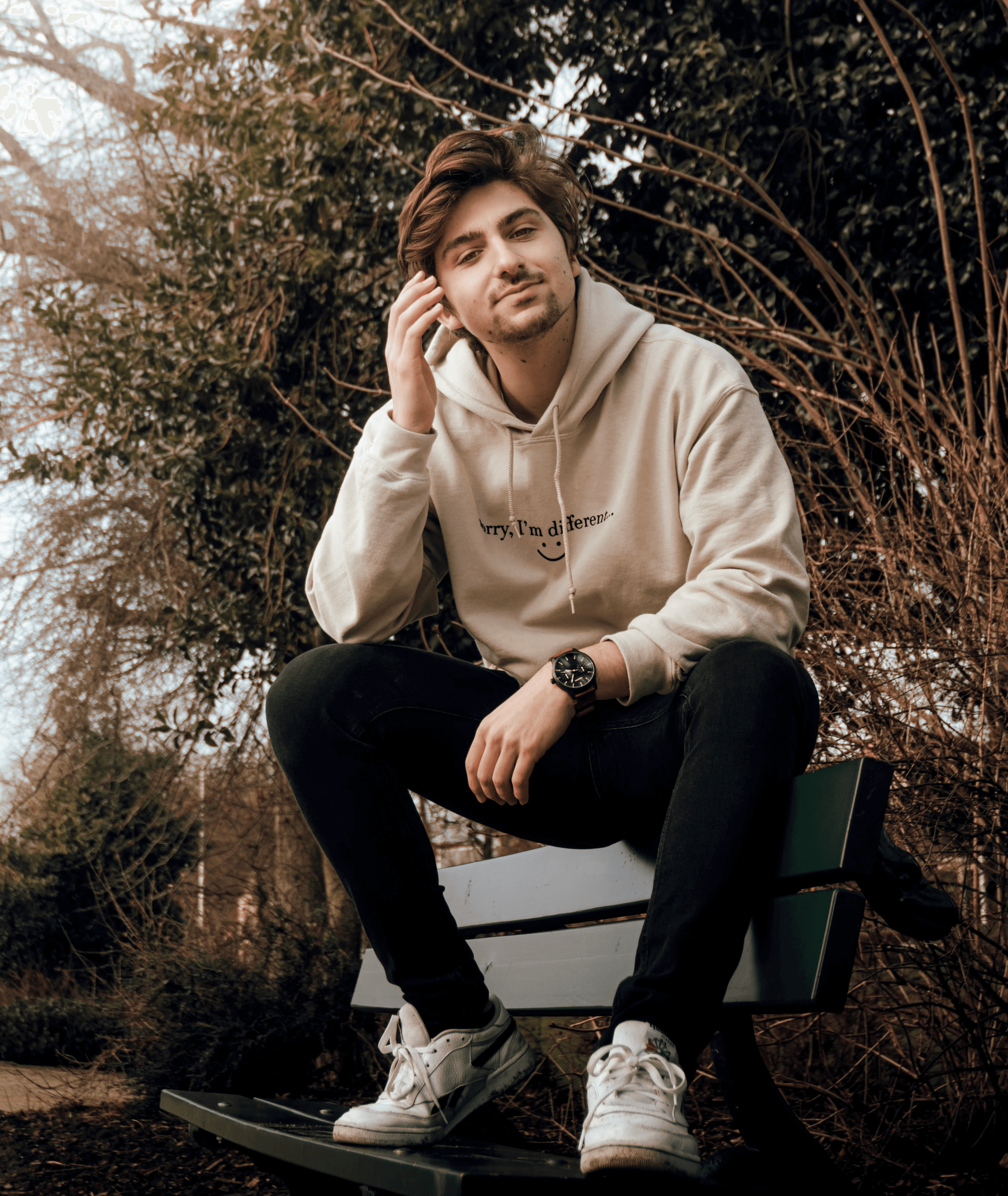 Professional male model portrait with red and teal studio lighting, featuring a black turtleneck and luxury smartwatch against a dark background.