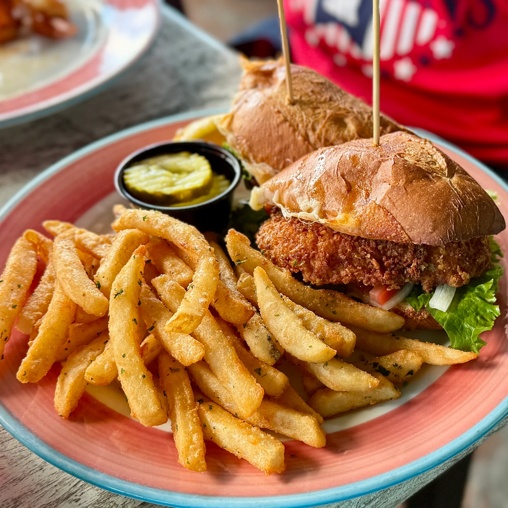 Two fried fish sandwiches with seasoned fries and pickles at Pilot House Marina.