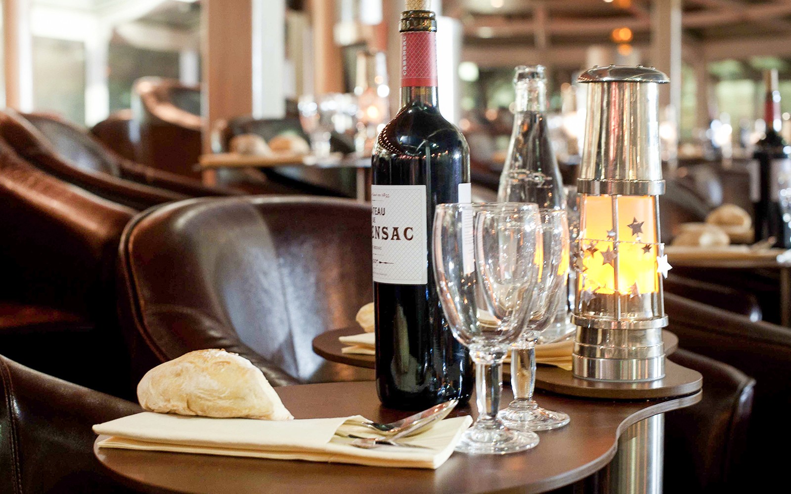 在巴黎塞纳河游船上的晚餐桌上摆放着葡萄酒和面包。