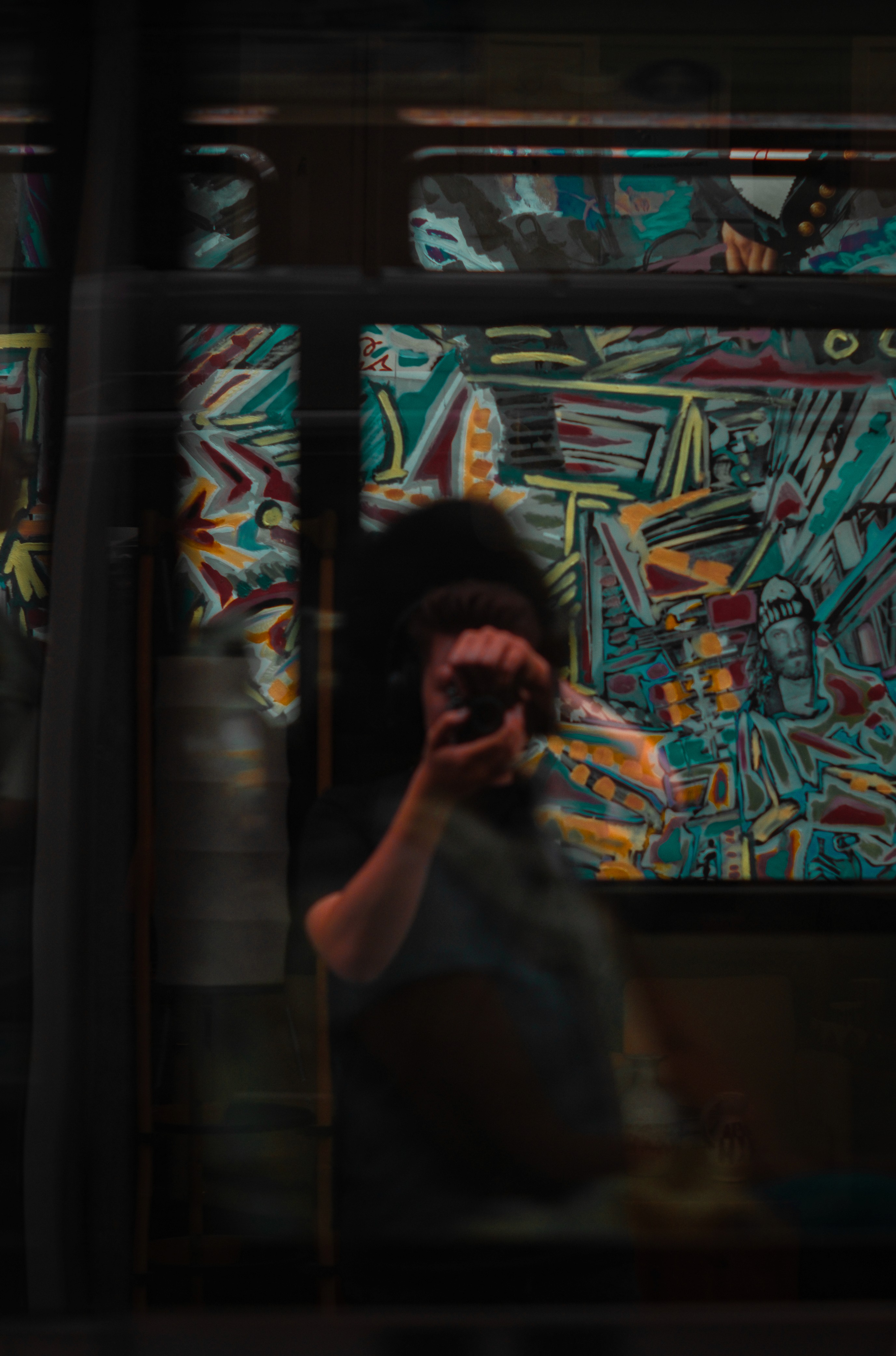 A thoughtful young person with dark hair gazes to the side, captured in soft black and white lighting.