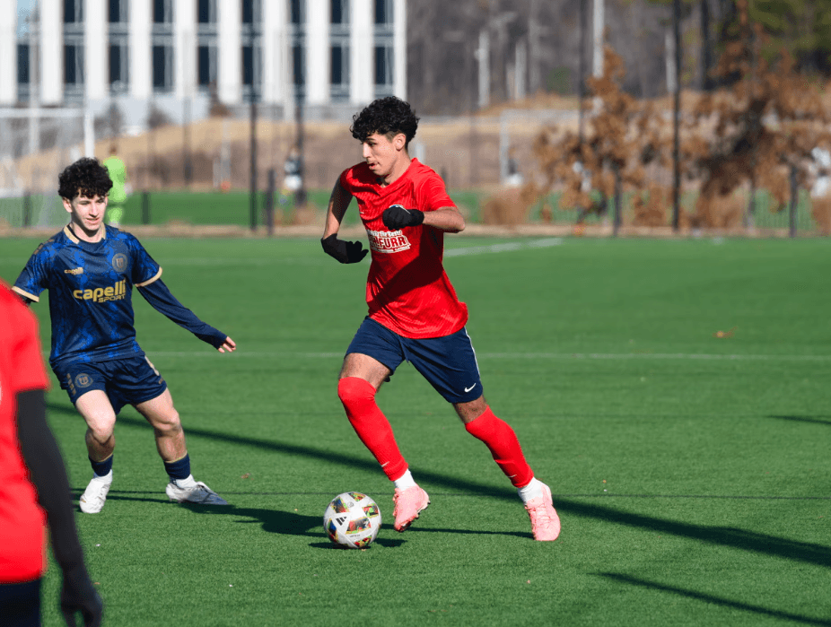Smiling woman sitting at desk with a computer, surrounded by plants.