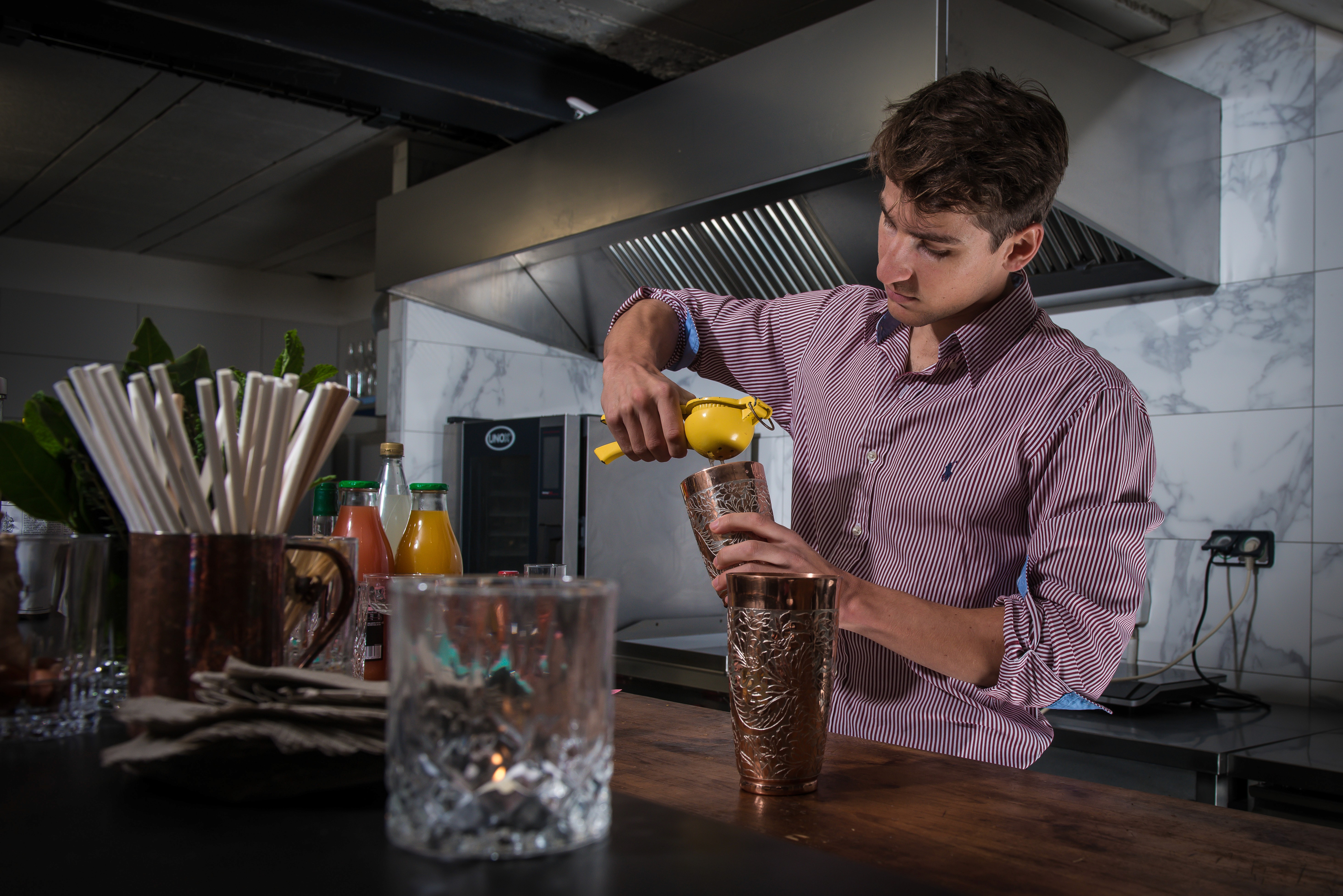 Barman presse un citron dans un shaker