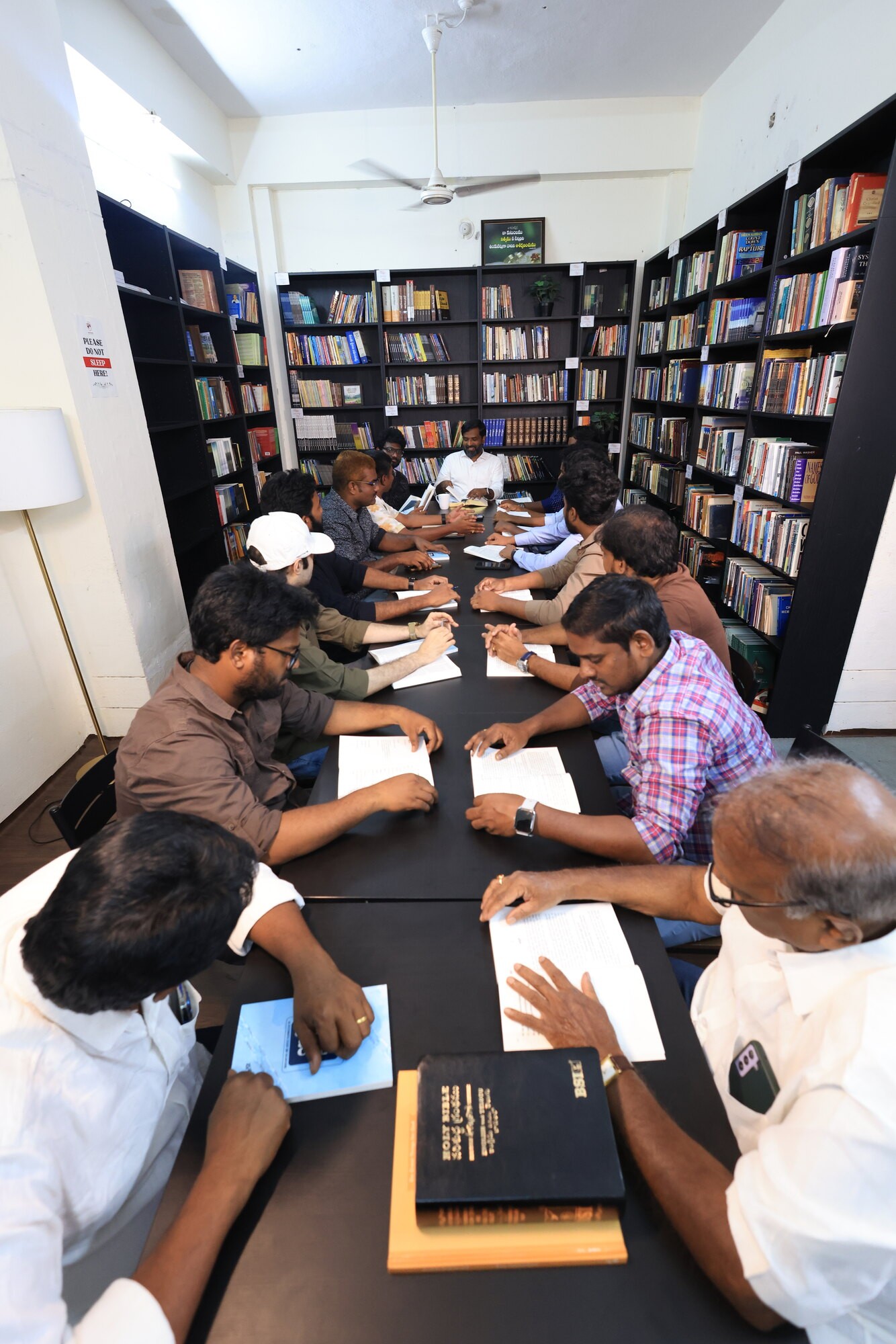 Men seated along a long table in the ministry library