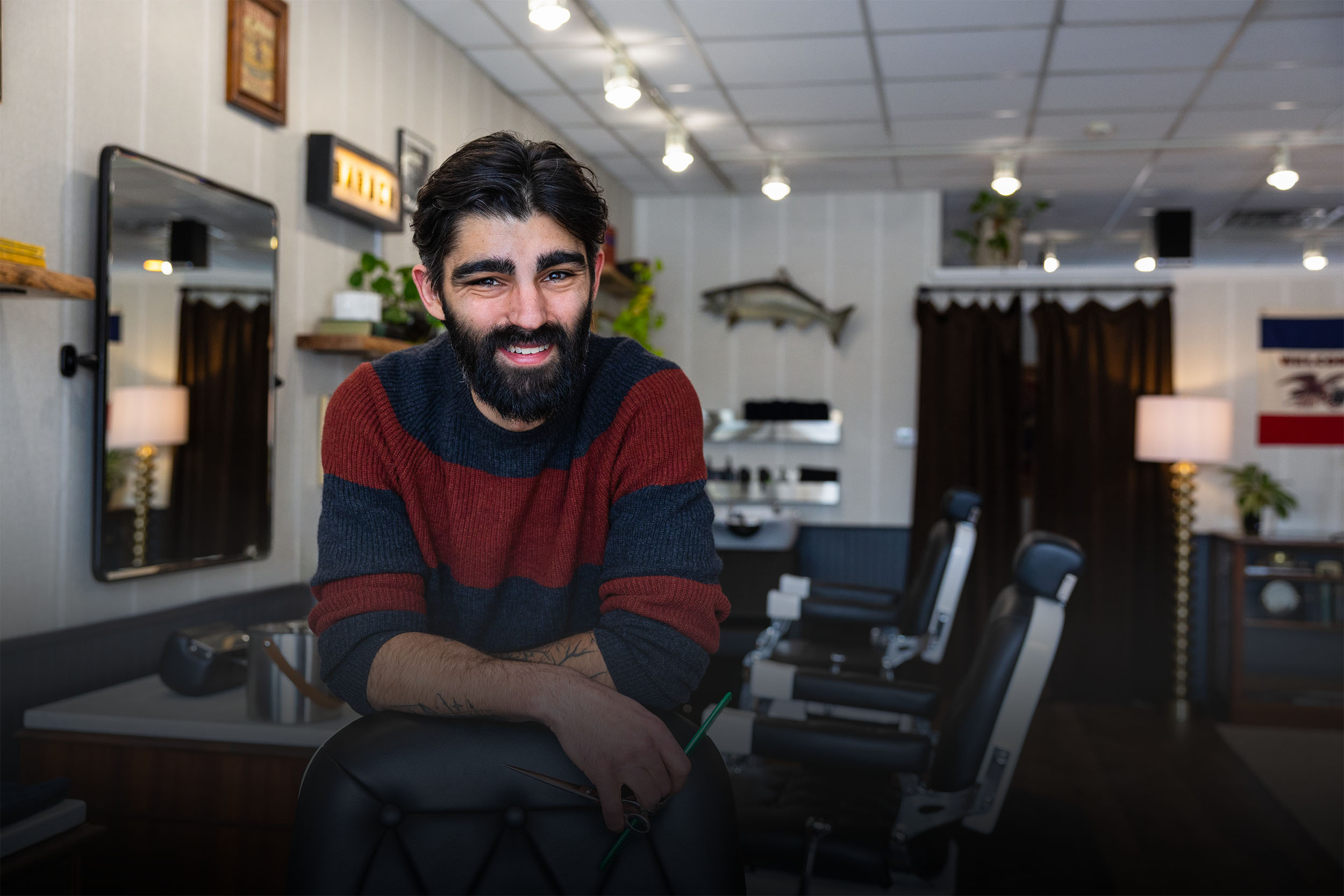 Portrait of Adam Calderone, barber and owner of Calderone’s Barbershop, inside the shop workspace