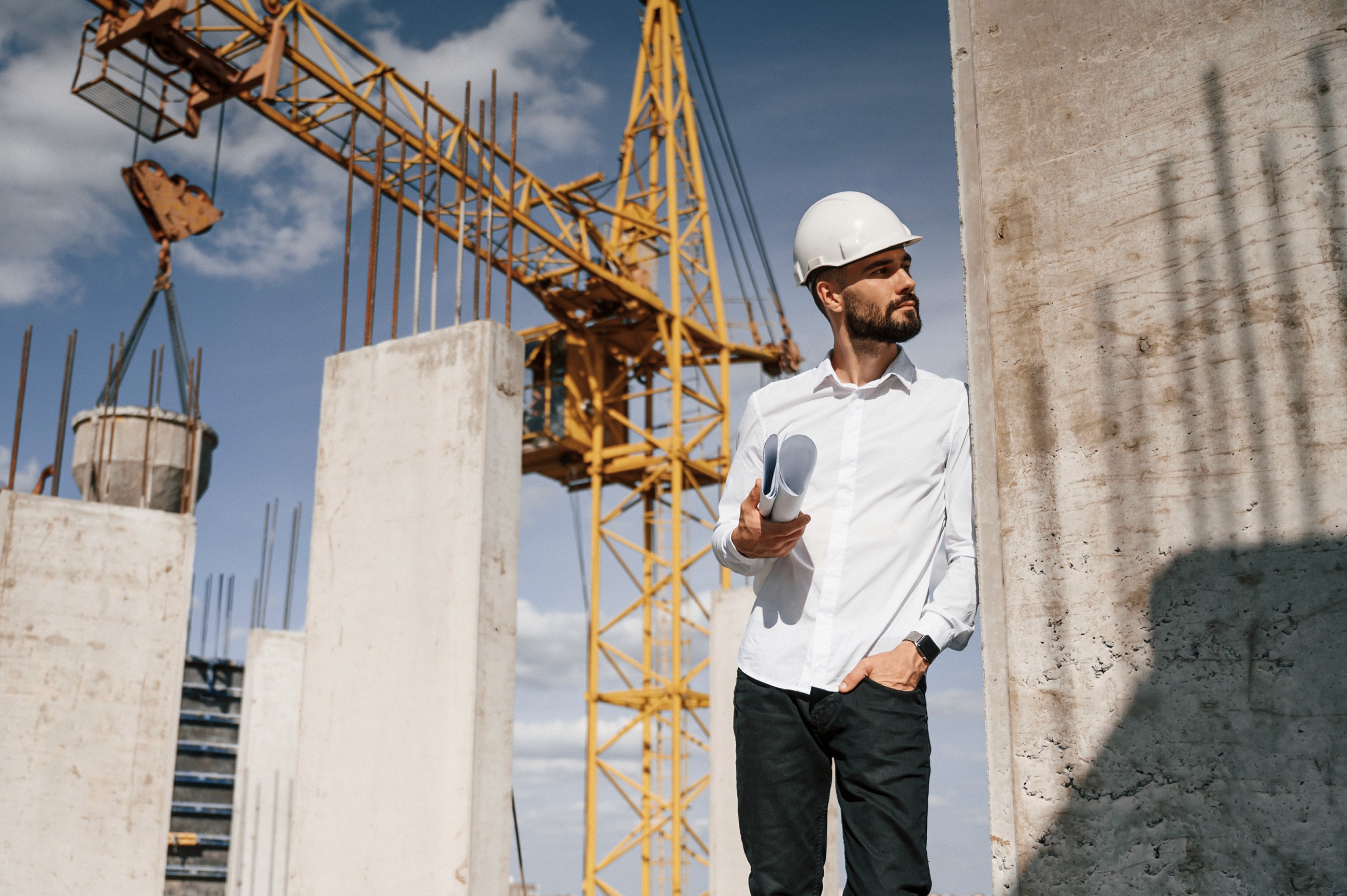 Een projectleider die tevreden naar een werf kijkt.