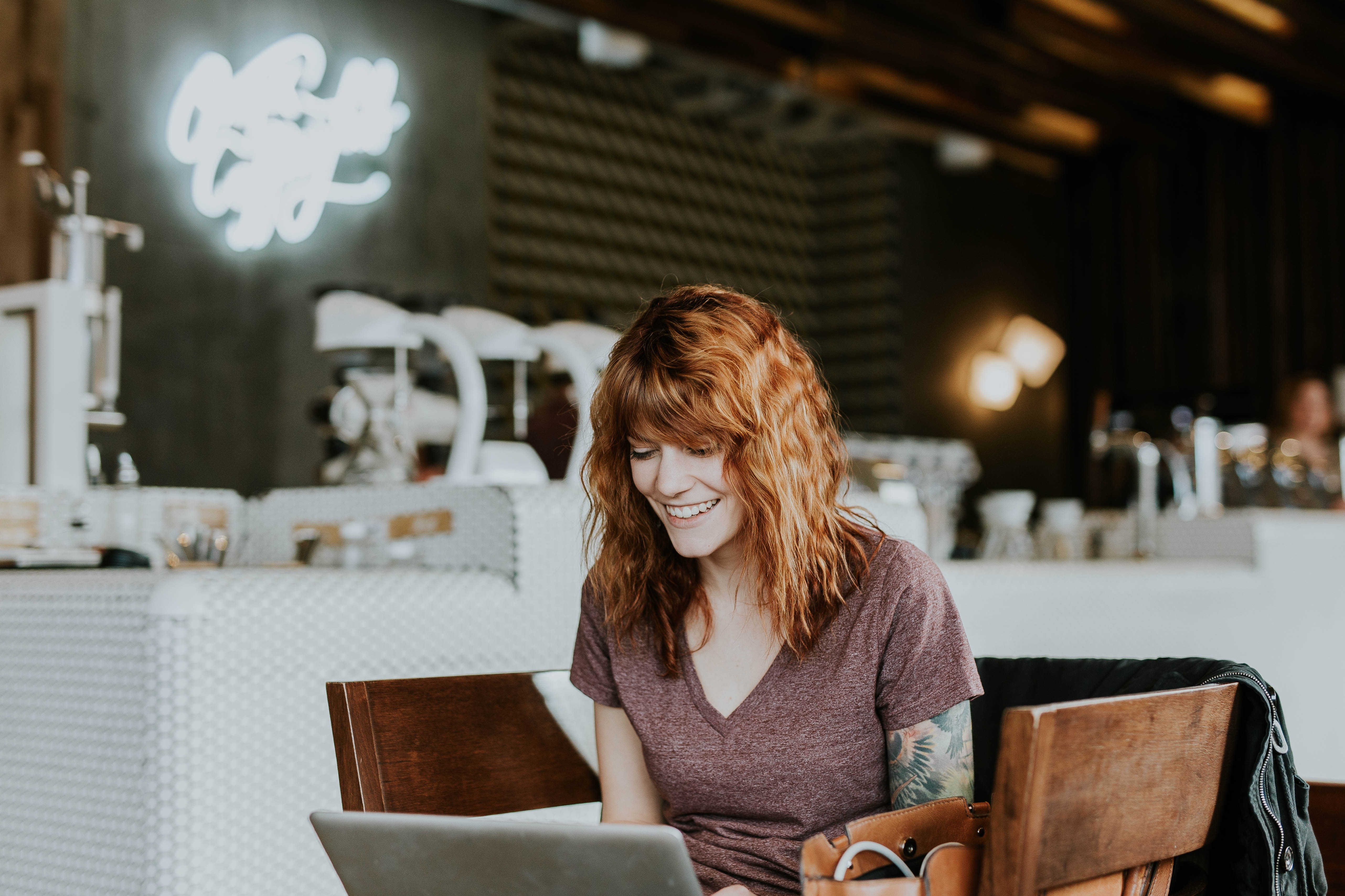 Woman smiling at computer screen while managing her online brand community