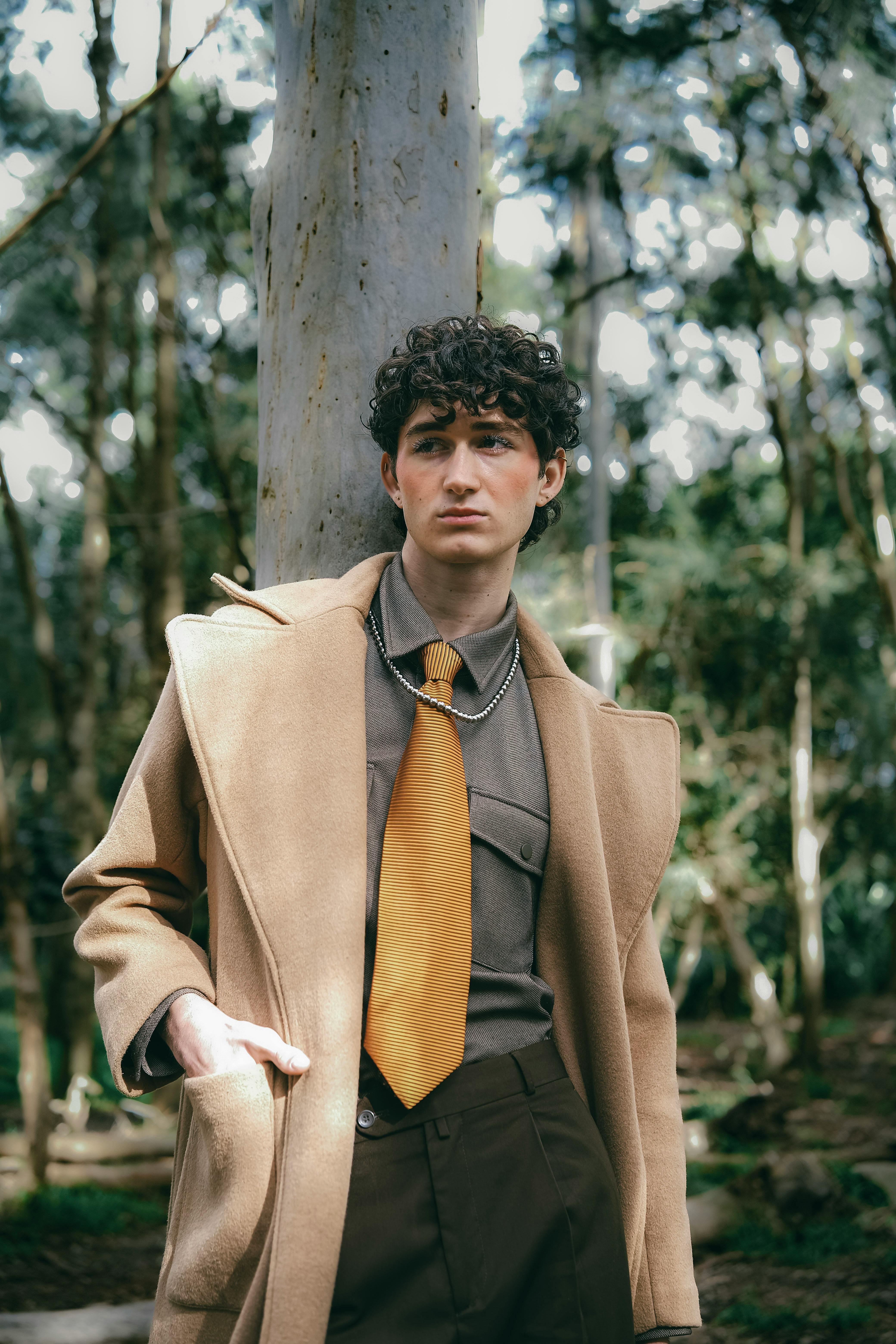 Profile image of LinkedPhone customer - stylish caucasian man with dark curly hair standing next to tree
