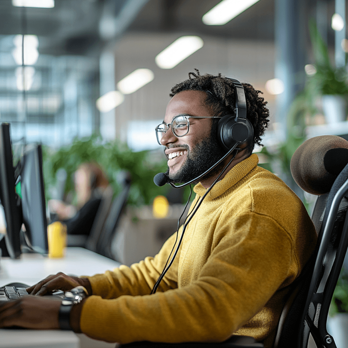 Black man wearing a yellow shirt and smiling