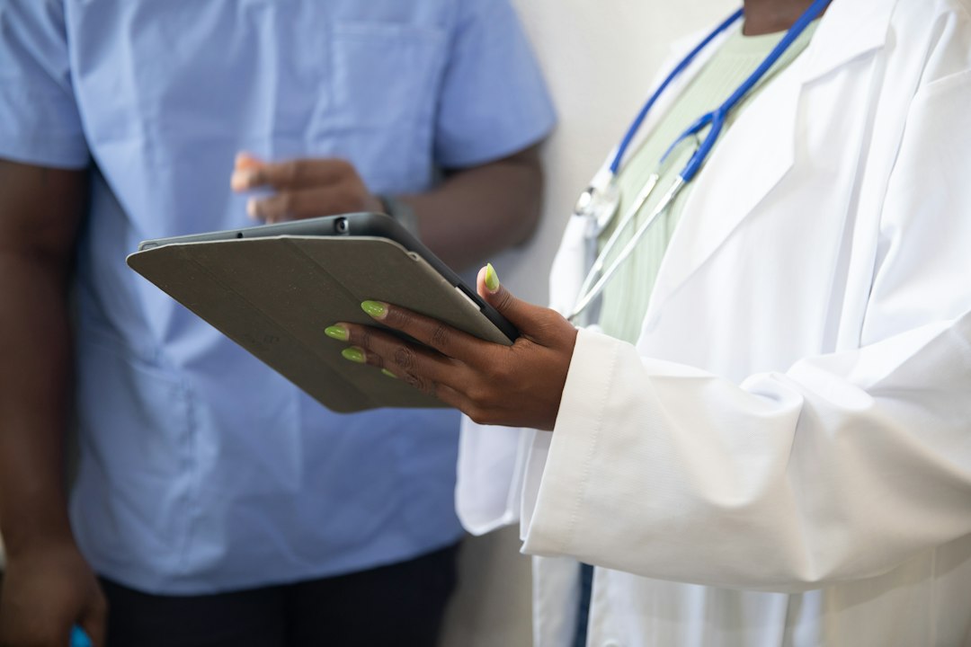 healthcare administrator looking at a laptop, high-tech interface with glowing data points, hospital office setting, early morning sunlight through glass, professional atmosphere