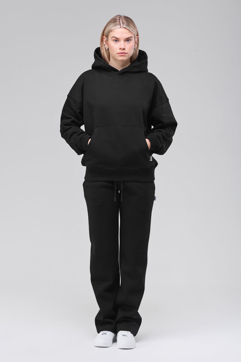 Model wearing black boxy hoodie, full figure