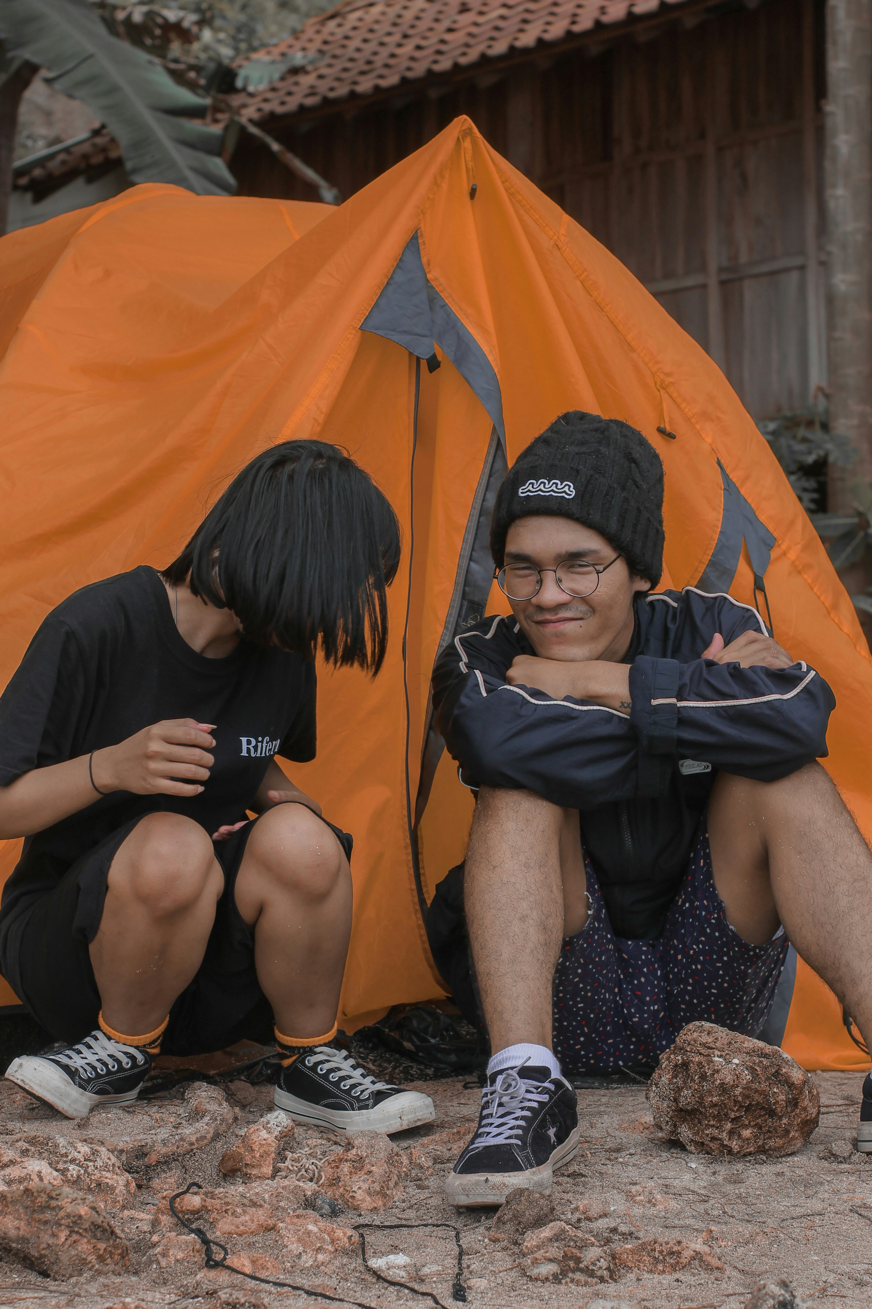 a man and a woman sitting in front of a tent