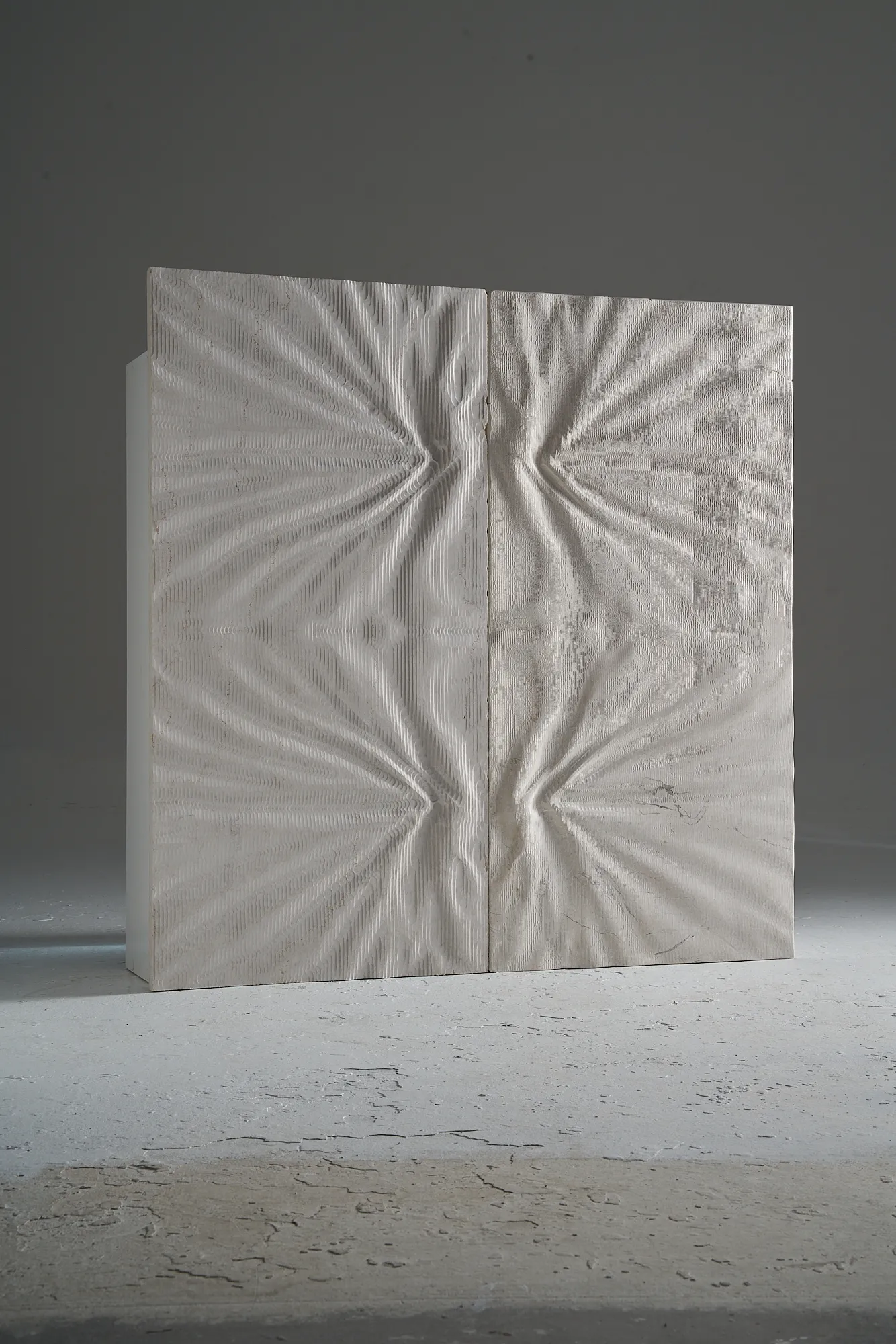 Two freestanding Curtis marble wall panels forming a complementary composition of gathered and stretched surface reliefs.