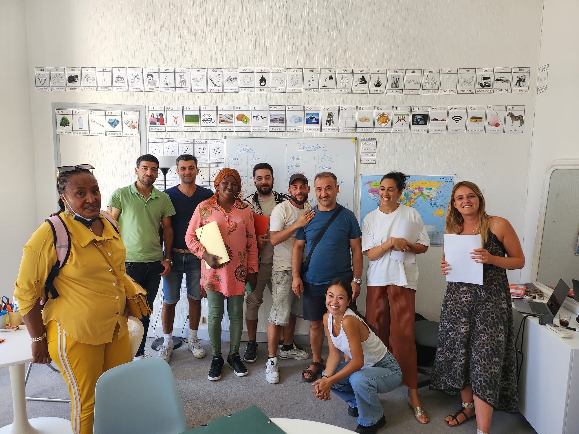Hands typing on a laptop keyboard on a wooden desk, wearing a brown ribbed sweater