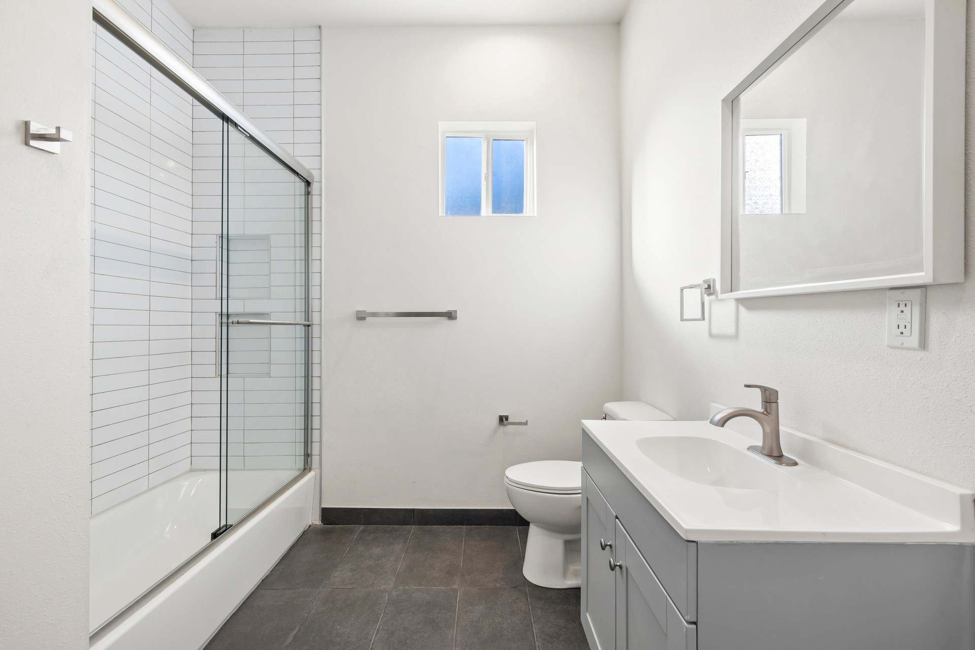 Renovated bathroom with walk in shower, modern vanity, and updated tile finishes at 1038 E 53rd