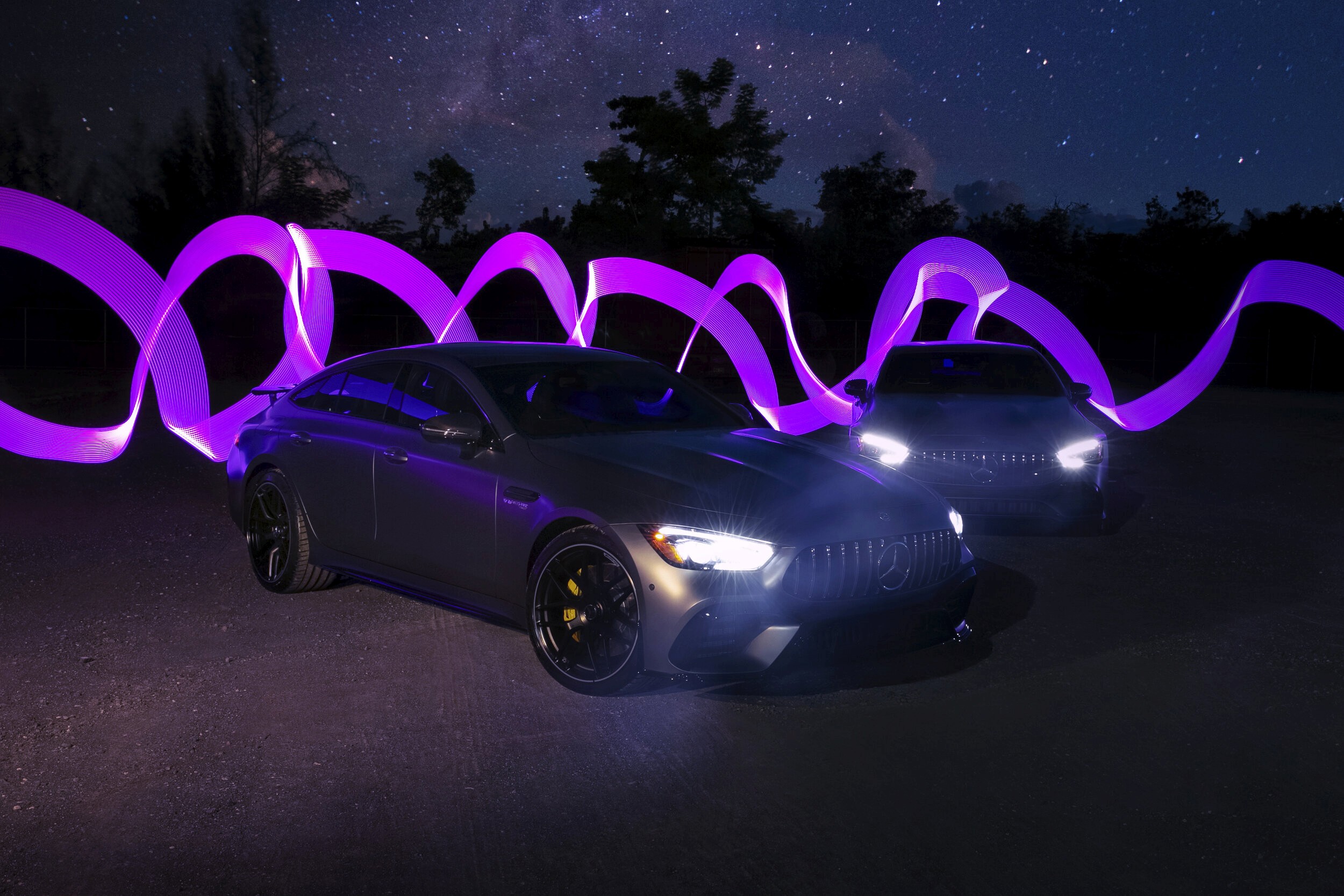 Two Mercedes-Benz AMG GT cars with light painting behind them at night, shot at Garage Isla Verde, Carolina, Puerto Rico.