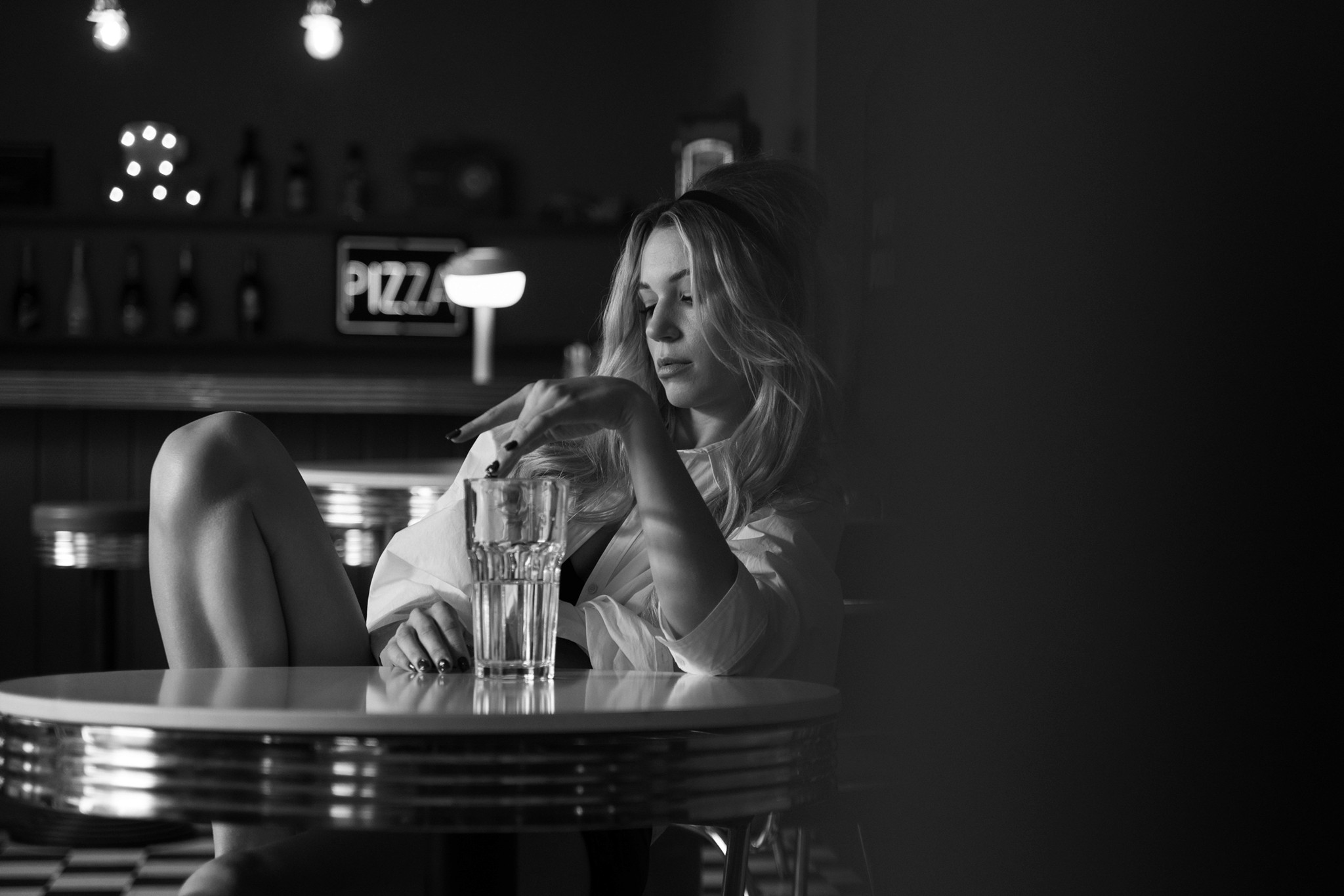 Agnieszka Czyzkowska fine art photography Warsaw woman at round table glass diner bar black and white