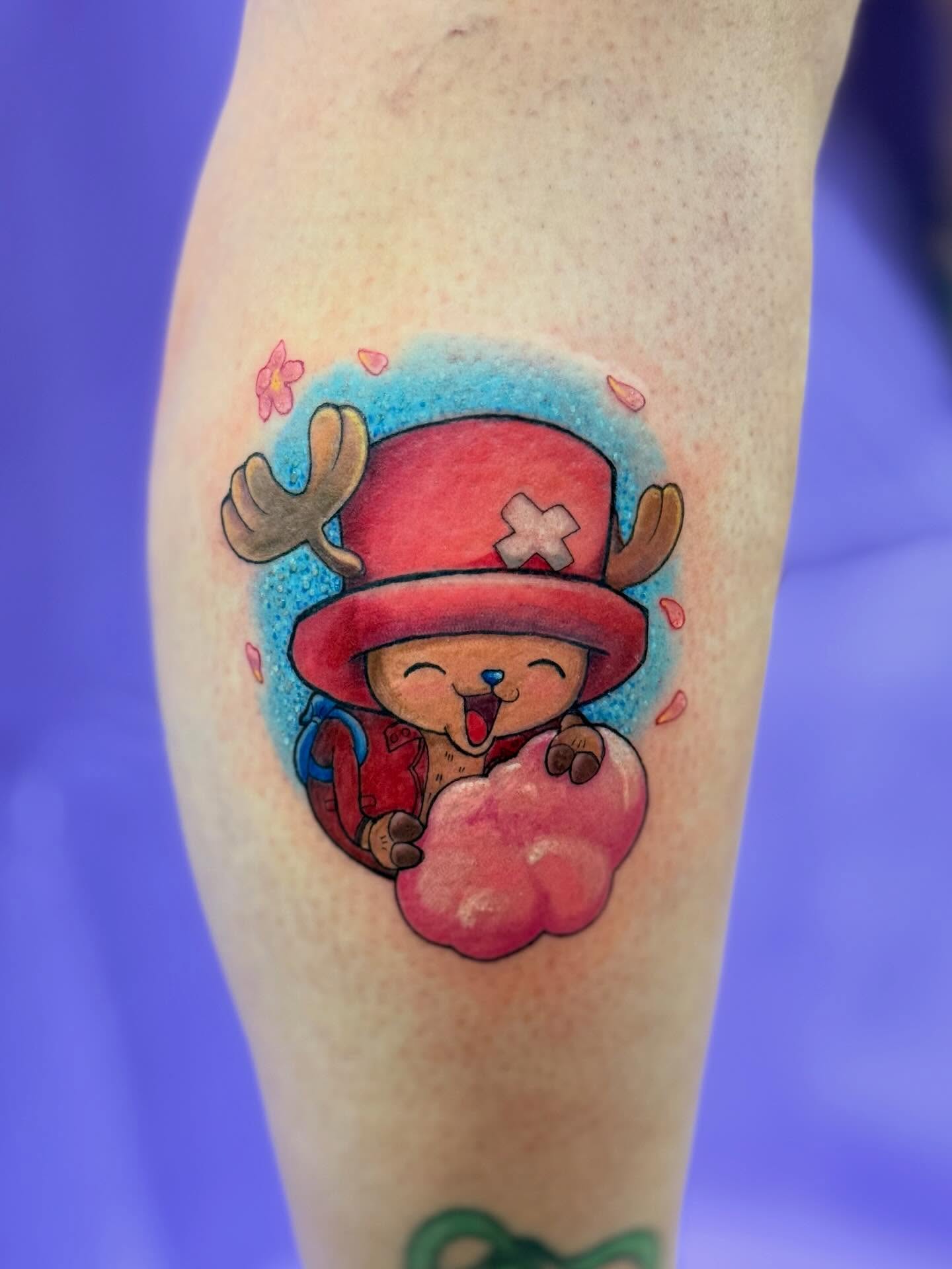 A forearm tattoo of Nezuko Kamado from Demon Slayer, depicted in a stylized anime art style. She is holding a sword.