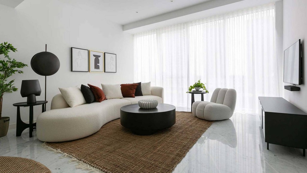  A sleek apartment with a roomy living area and kitchen, designed by The Pad by OMNIYAT.