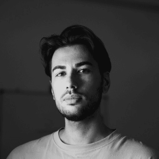 Portrait of a handsome man with dark hair and a beard, in black and white.