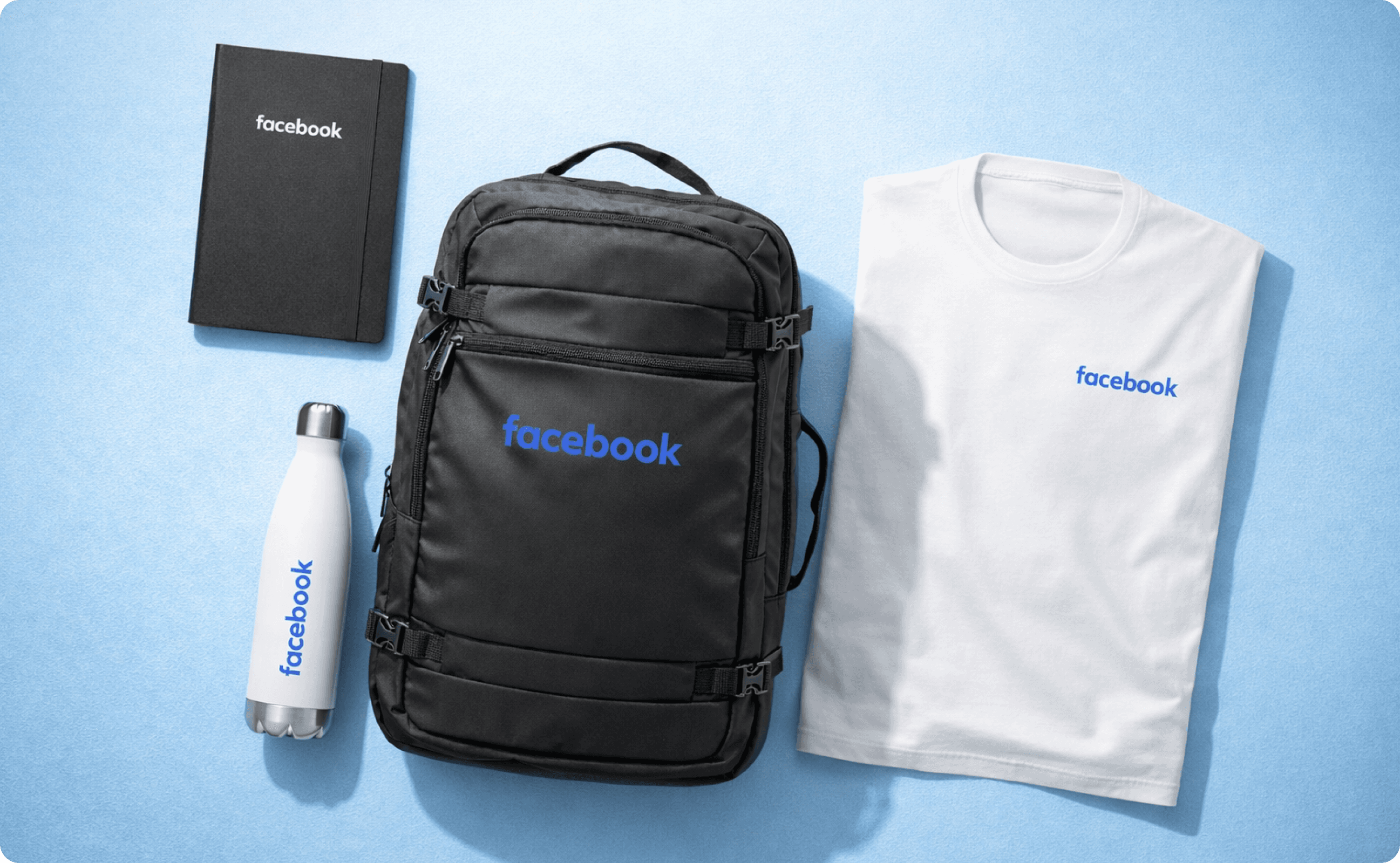 Inside Facebook/Meta's new hire swag kit: notebook, tumbler, bag, and t-shirt.