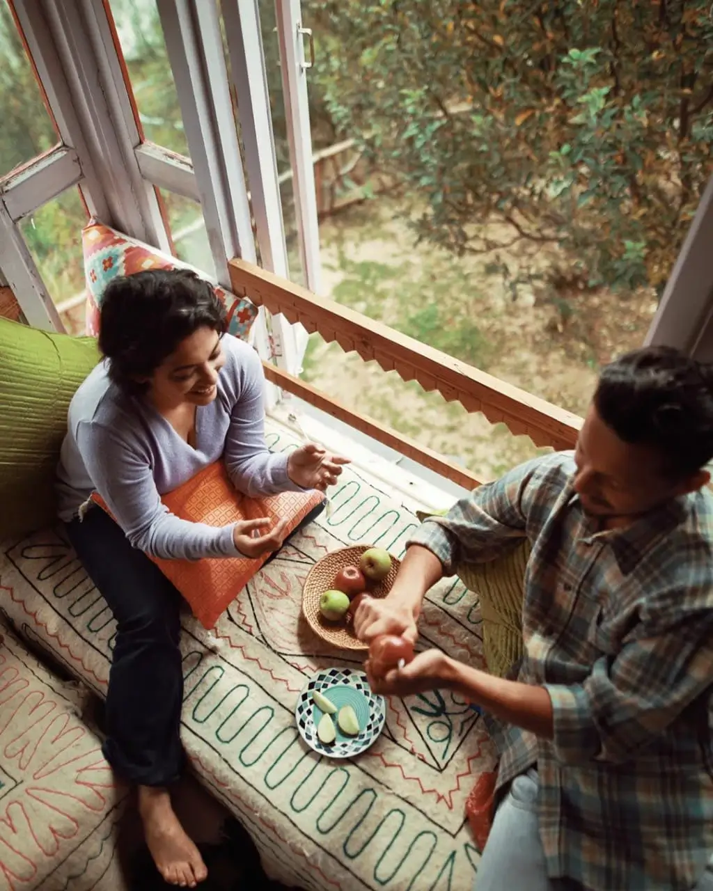 man wearing grey t-shirt standing in front of man sitting on chair