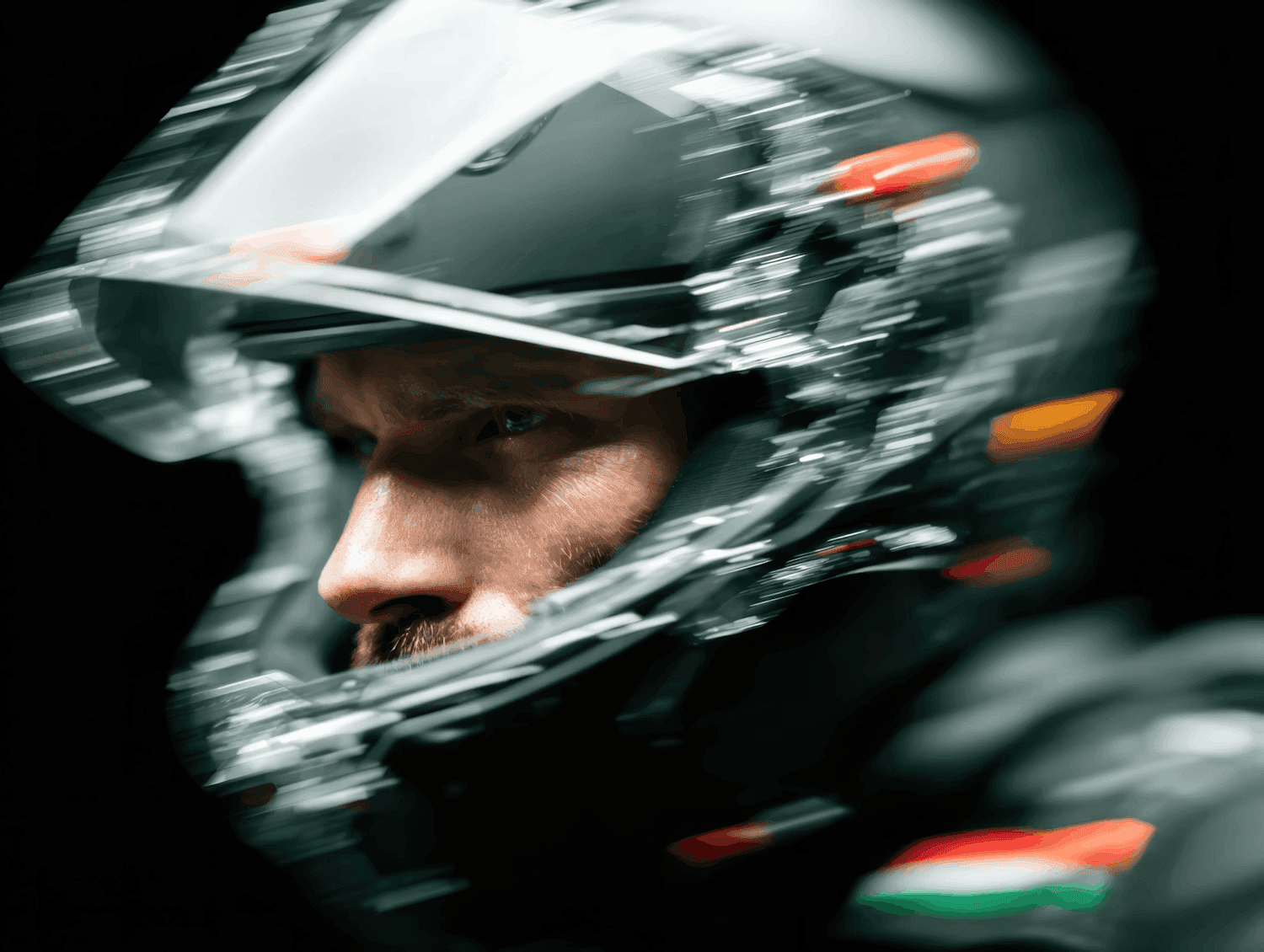 Man's intense face through a motion-blurred race helmet.