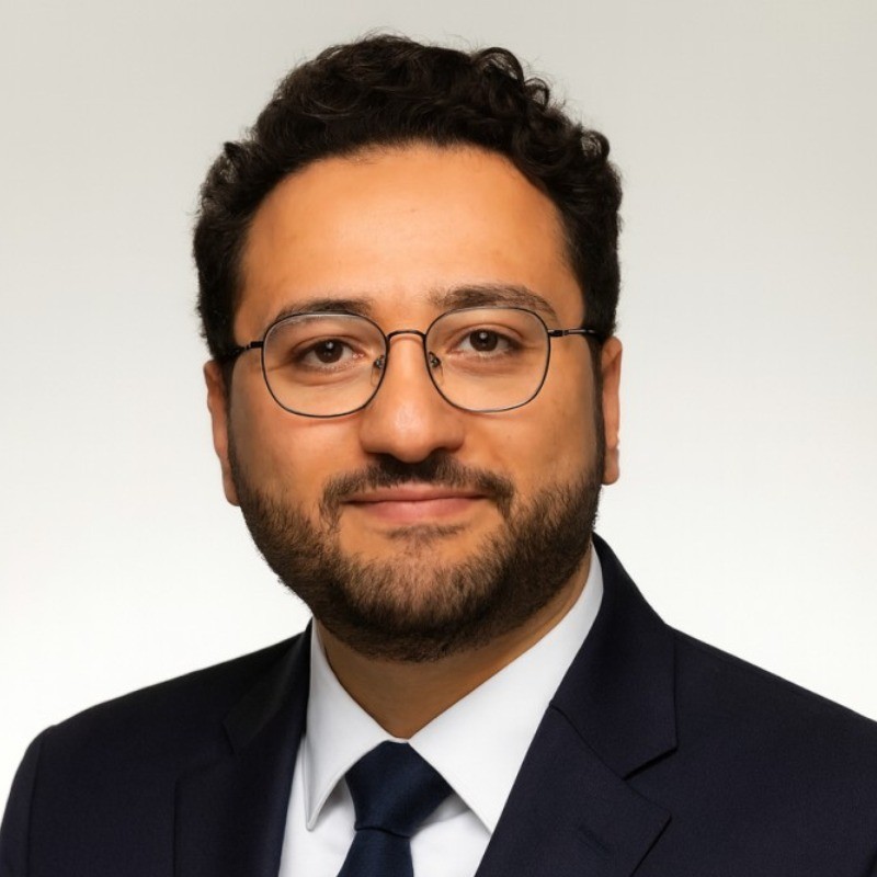 Smiling man with a blue shirt on a white background.