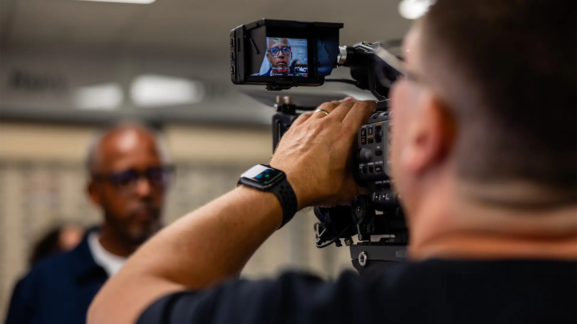Camera operator filming an interview, with focus on professional video production in action.