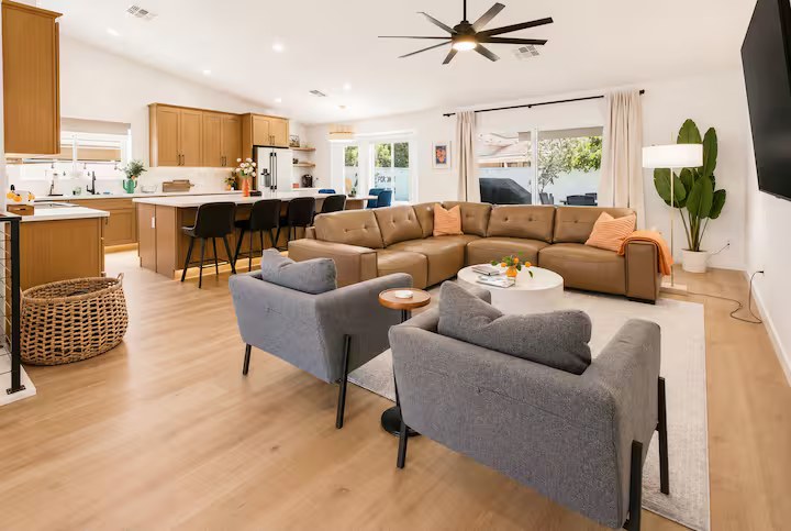 Spacious open-concept living area with comfortable seating for the whole group, high ceilings, and plenty of natural light.