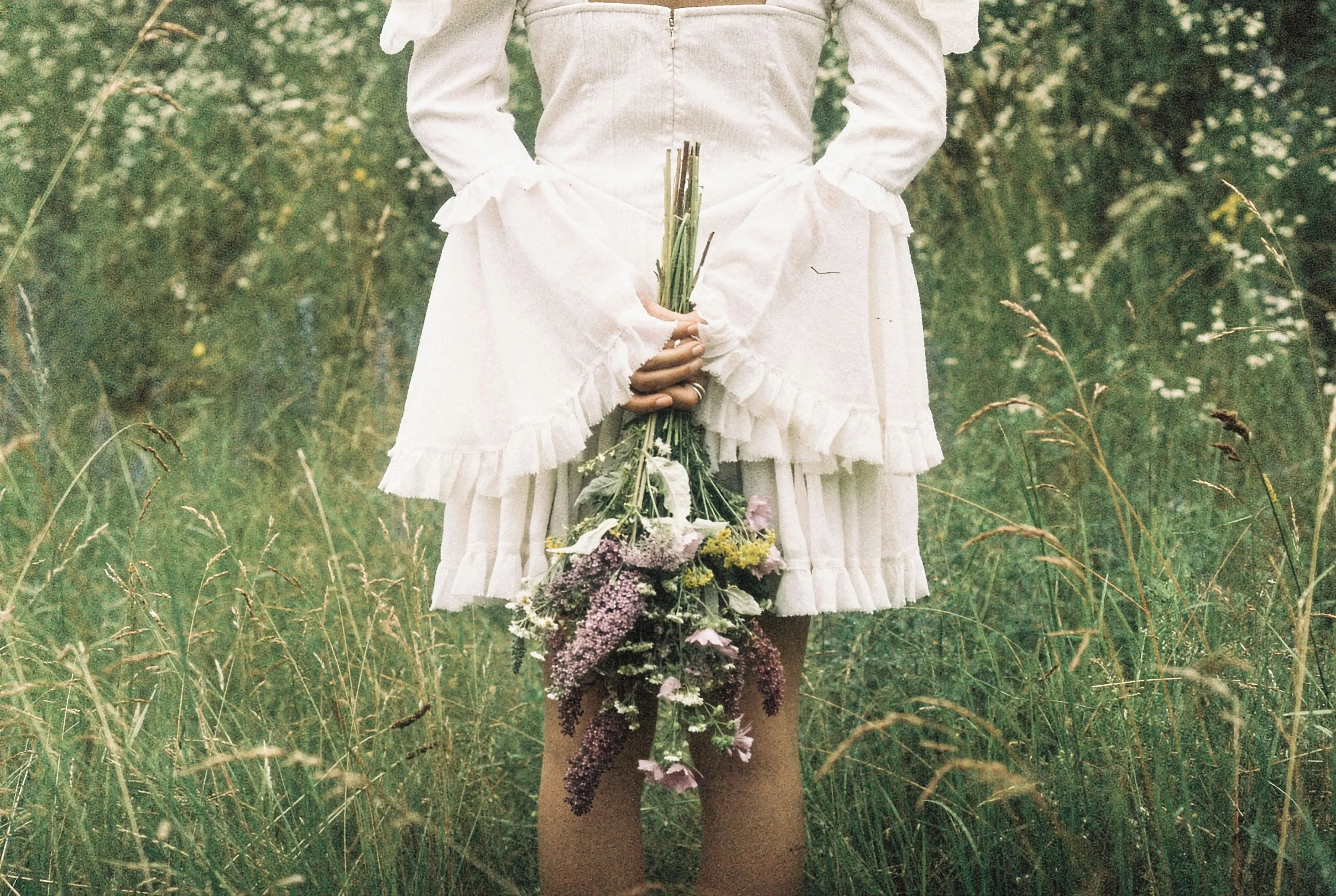 Blurry image of a woman dressed in white dress holding a bouqet.