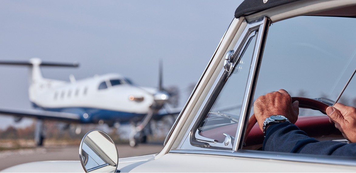 Client arriving at aircraft in car with Pilatus PC-12 on the tarmac
