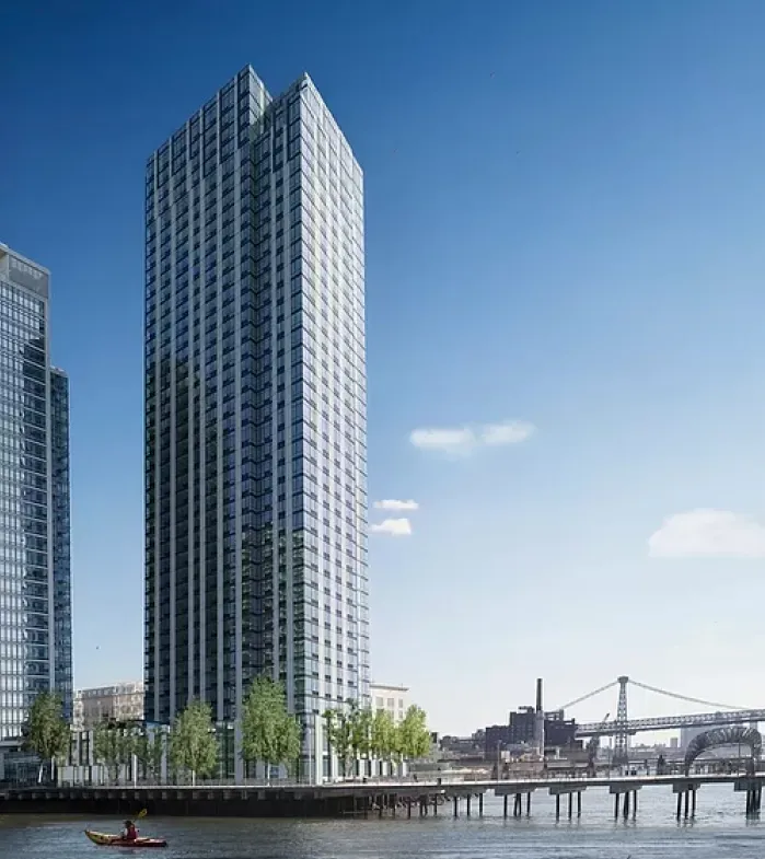 A boat floats in the water, surrounded by tall buildings reflecting in the calm surface.