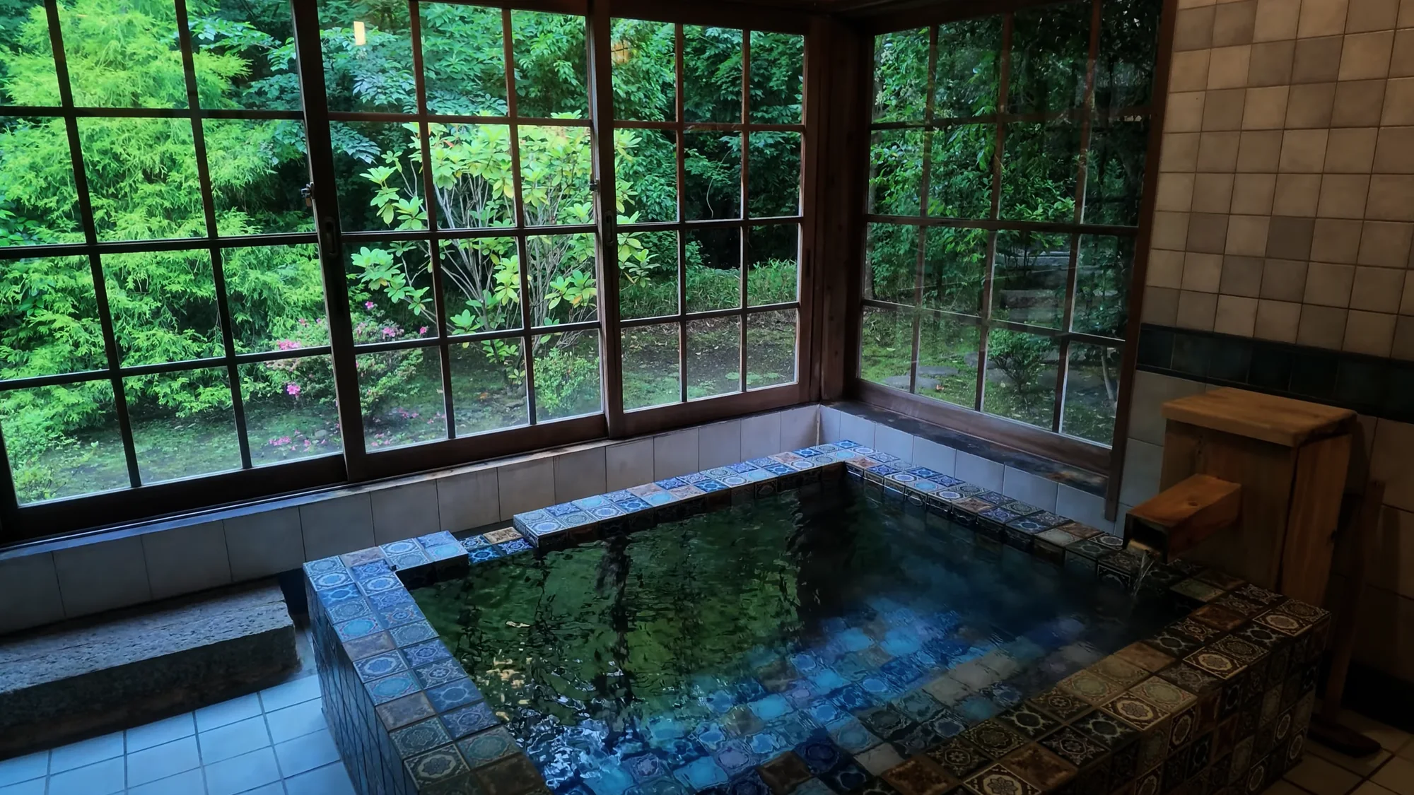An indoor stone bath with garden windows at a Kurokawa ryokan