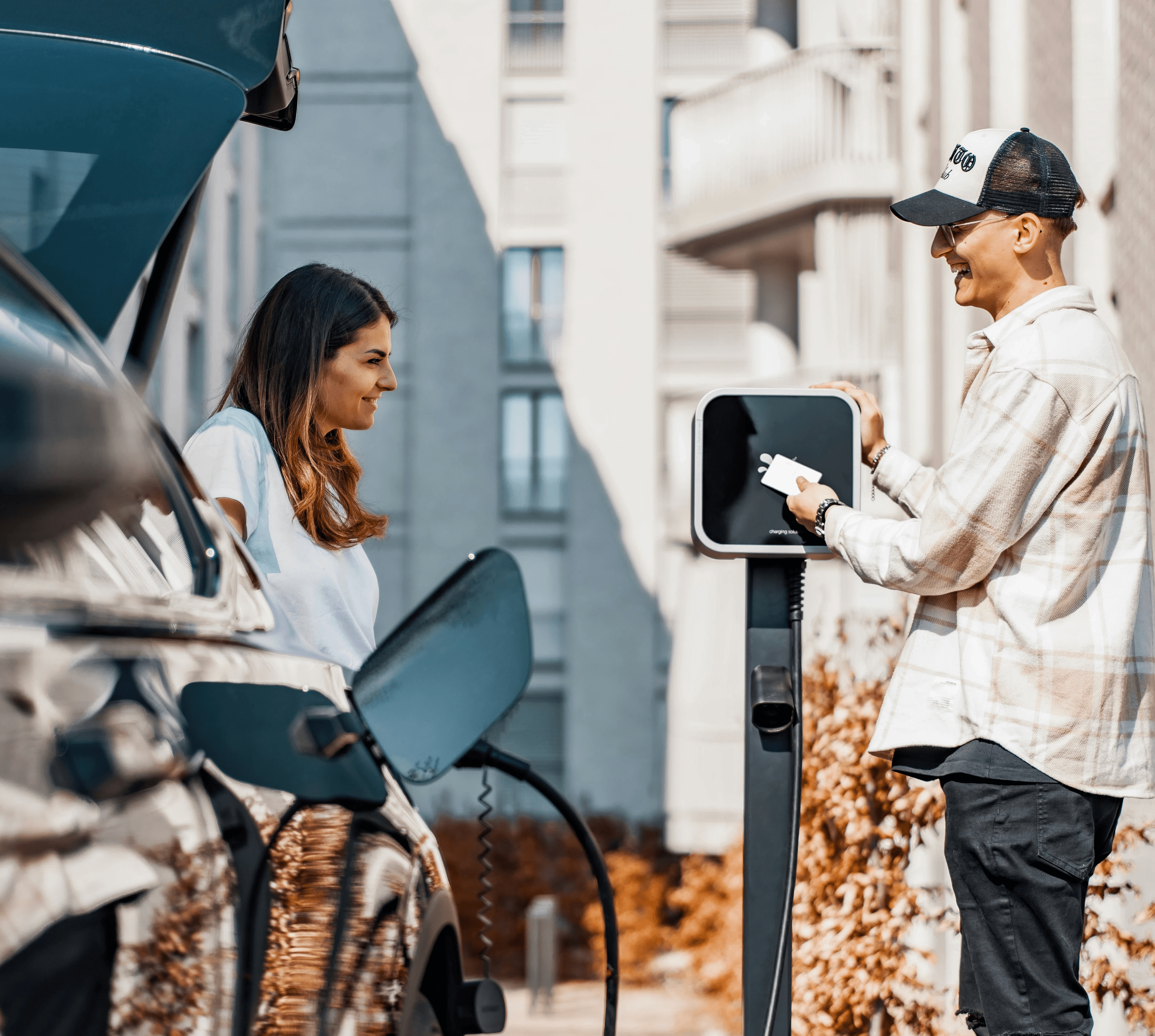 deux personnes qui rechargent un véhicule électrique