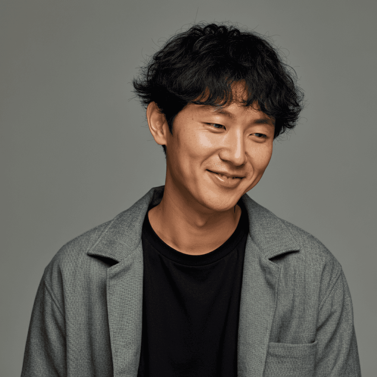 An asian man smiling looking down