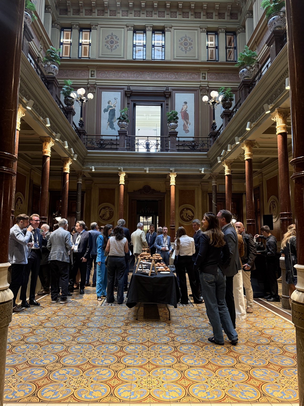 Guests networking in a grand historic hall during a corporate event