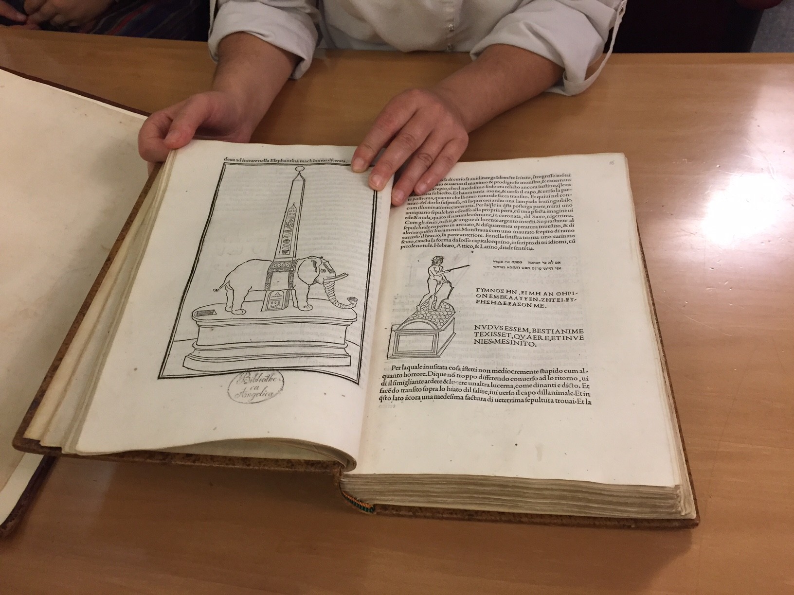Some drawings and text from an old book depicting an elephant near an obelisk and a man on a chest.