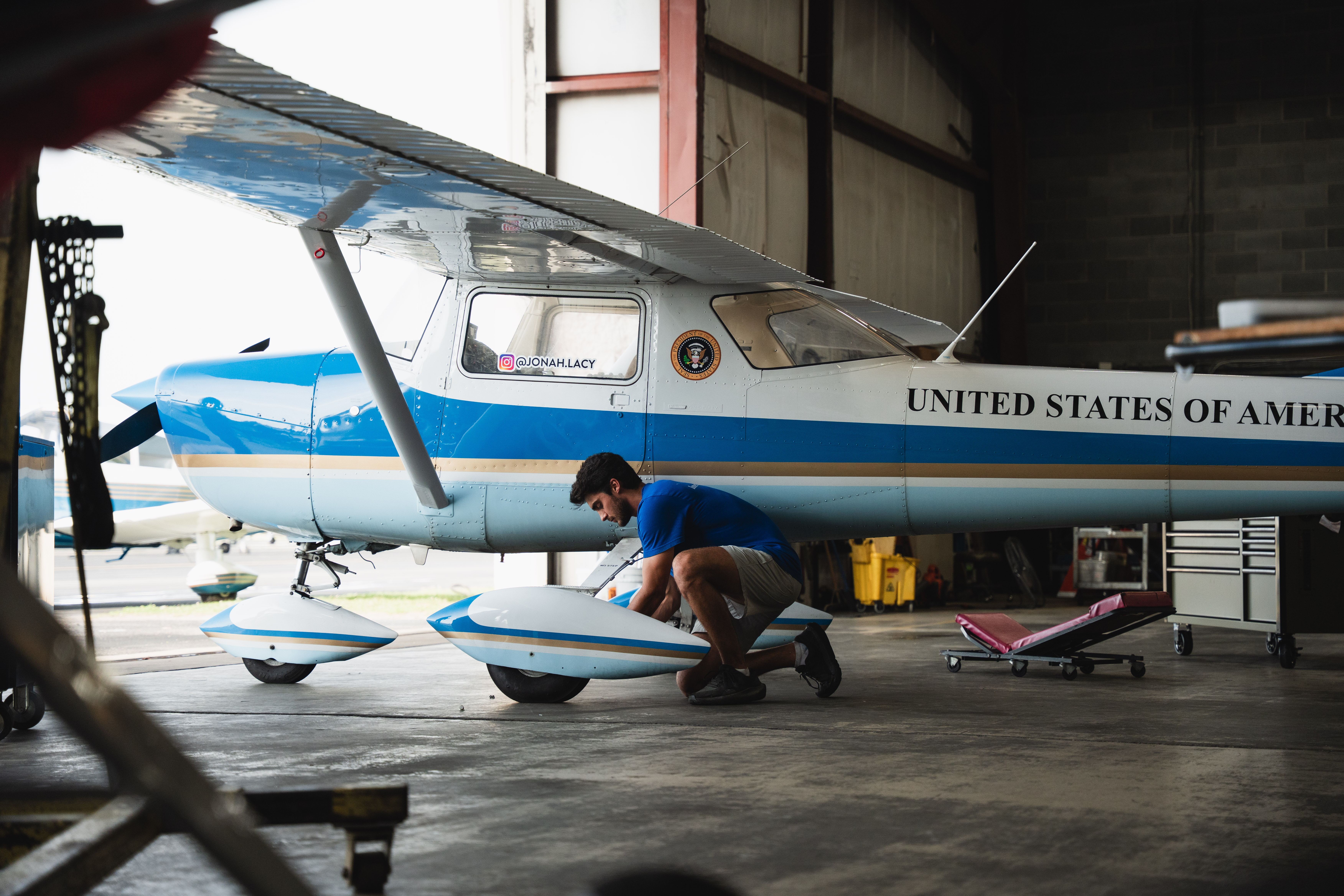 Group of four smiling colleagues standing indoors, wearing smart casual clothing.