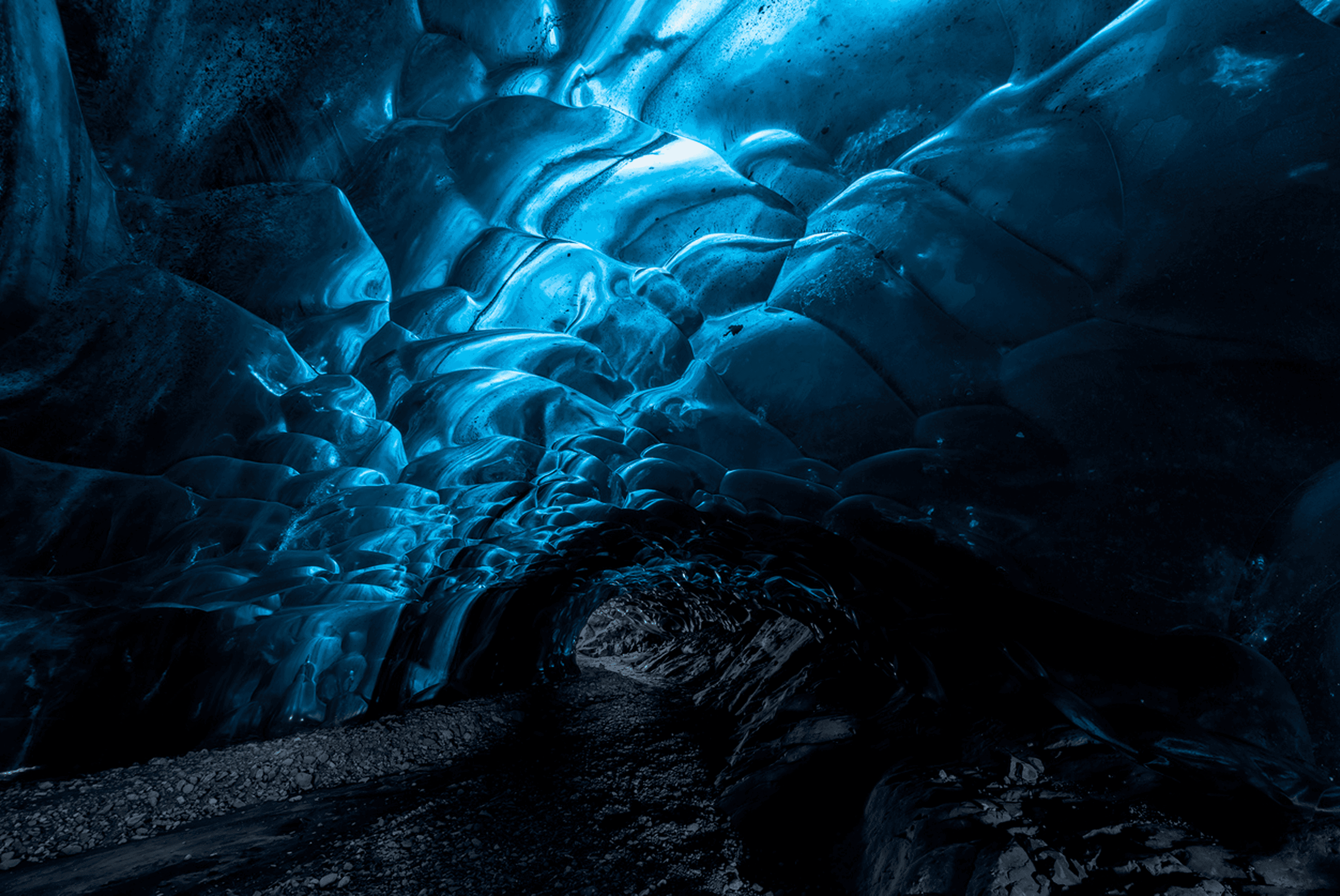 Blue ice cave with rocky floor