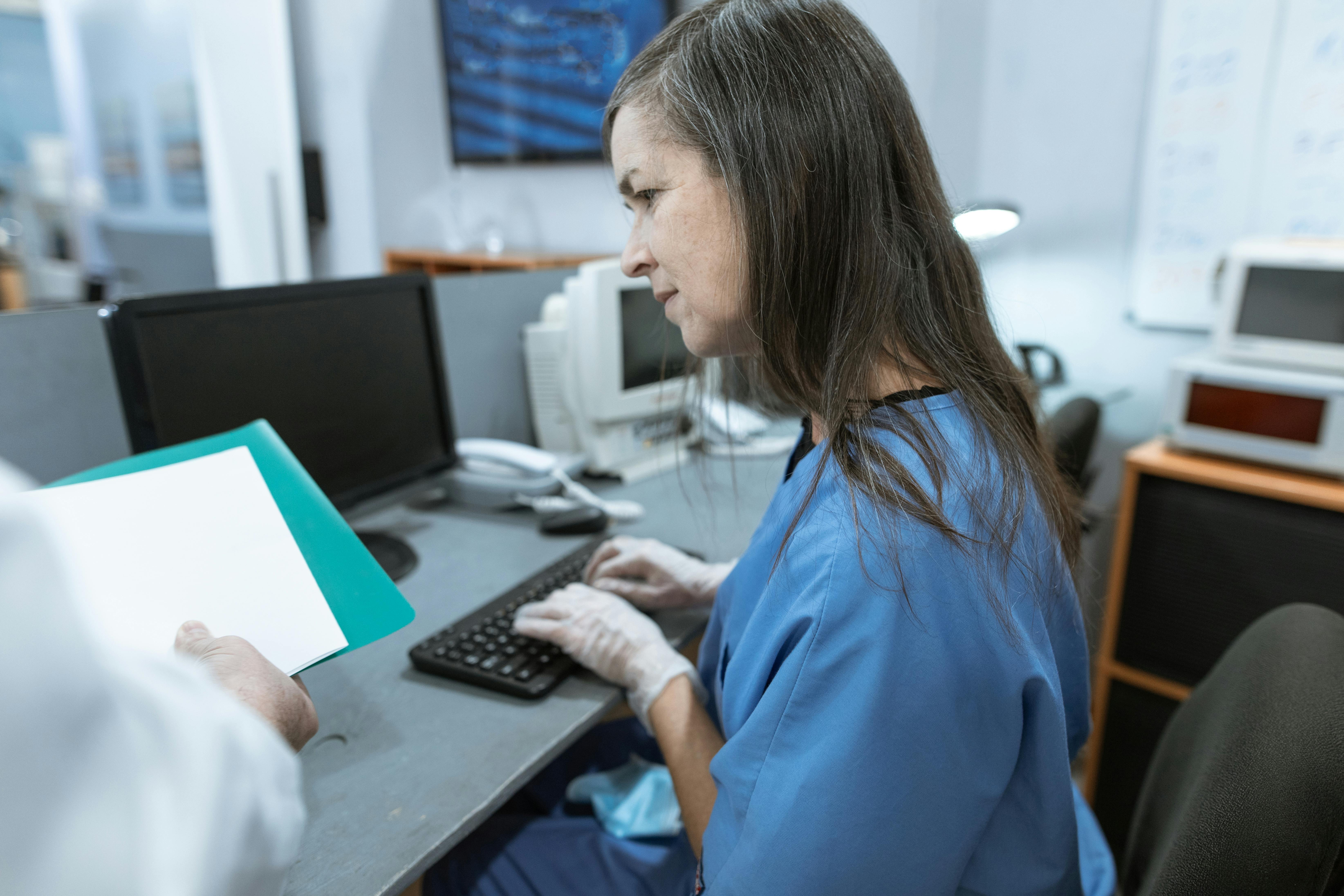 Dental receptionist entering records into computer
