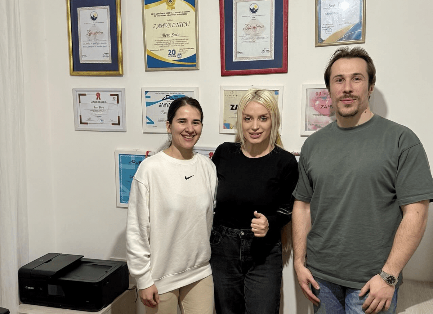 three people in front of diplomas