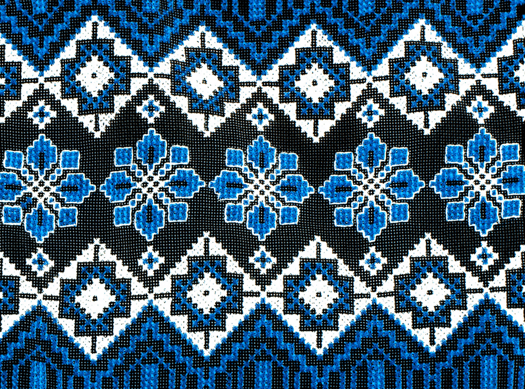 Blue textile with different shades of blue in square and floral geometric shapes.