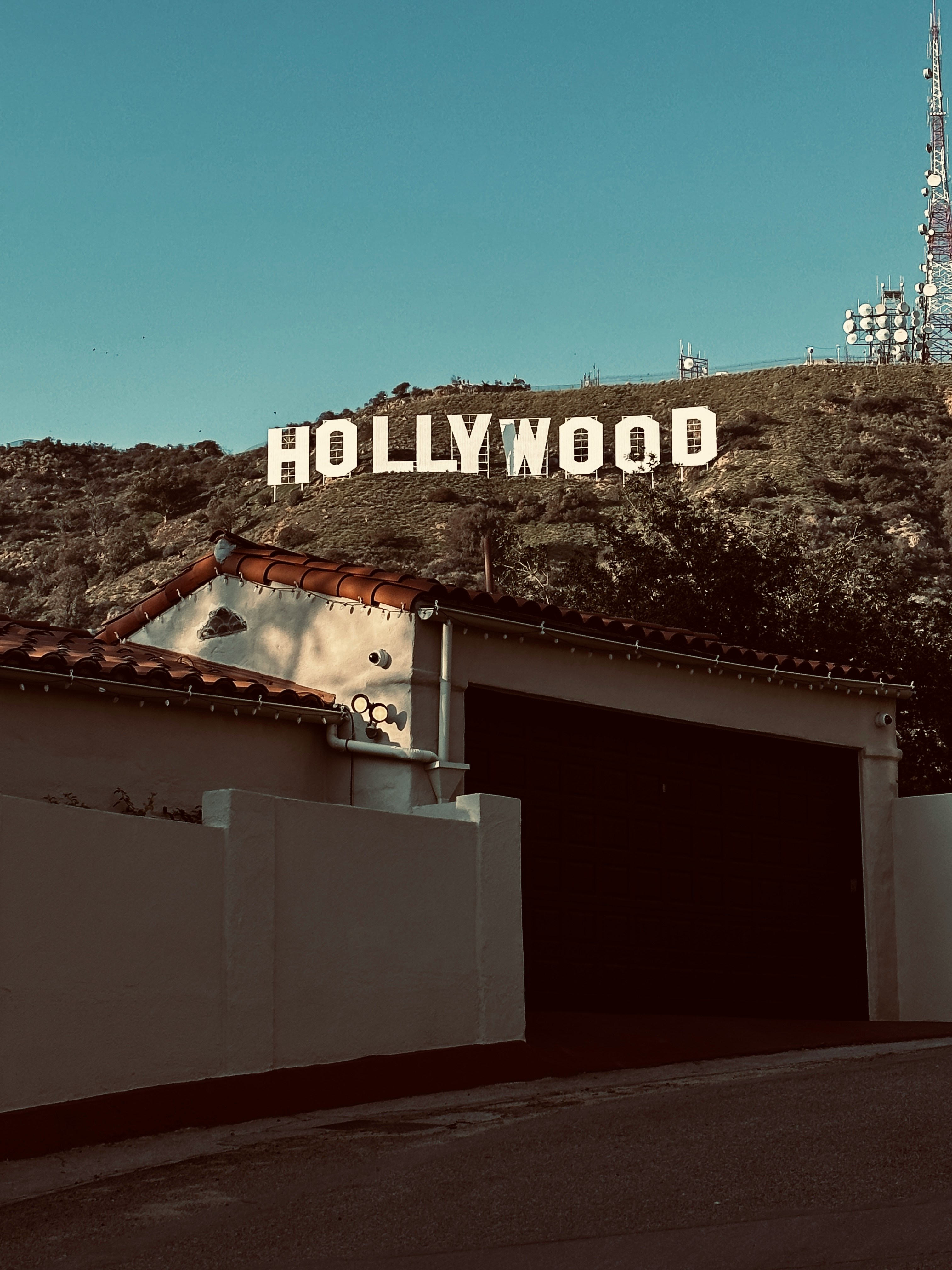 Hollywood Sign and Griffith Observatory antennas with a house in the foreground