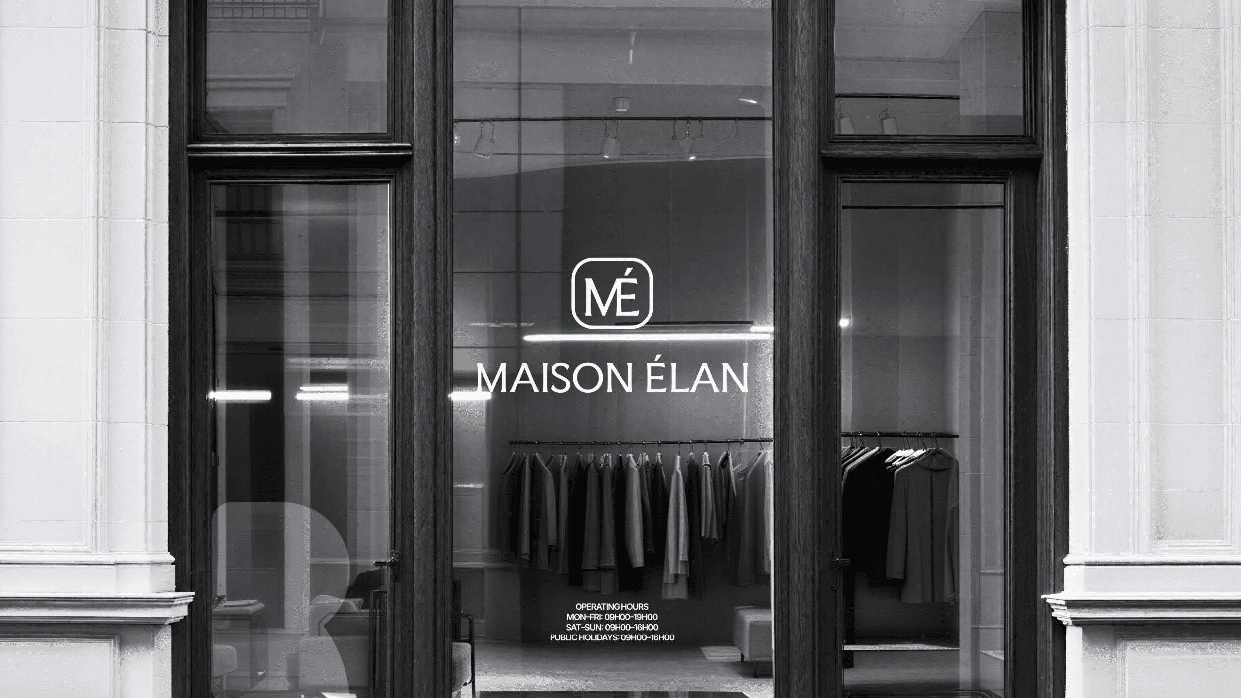A Maison Élan storefront. The brand logo is on the window in the center. A clothing rack is visible through the window.