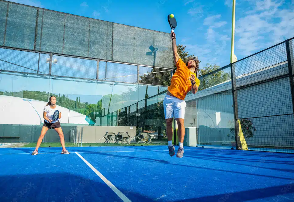 Padel player hitting the ball in the air