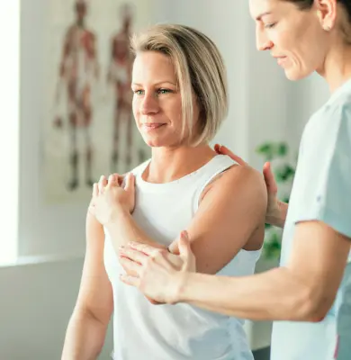 Mulher sendo atendida por fisioterapeuta.