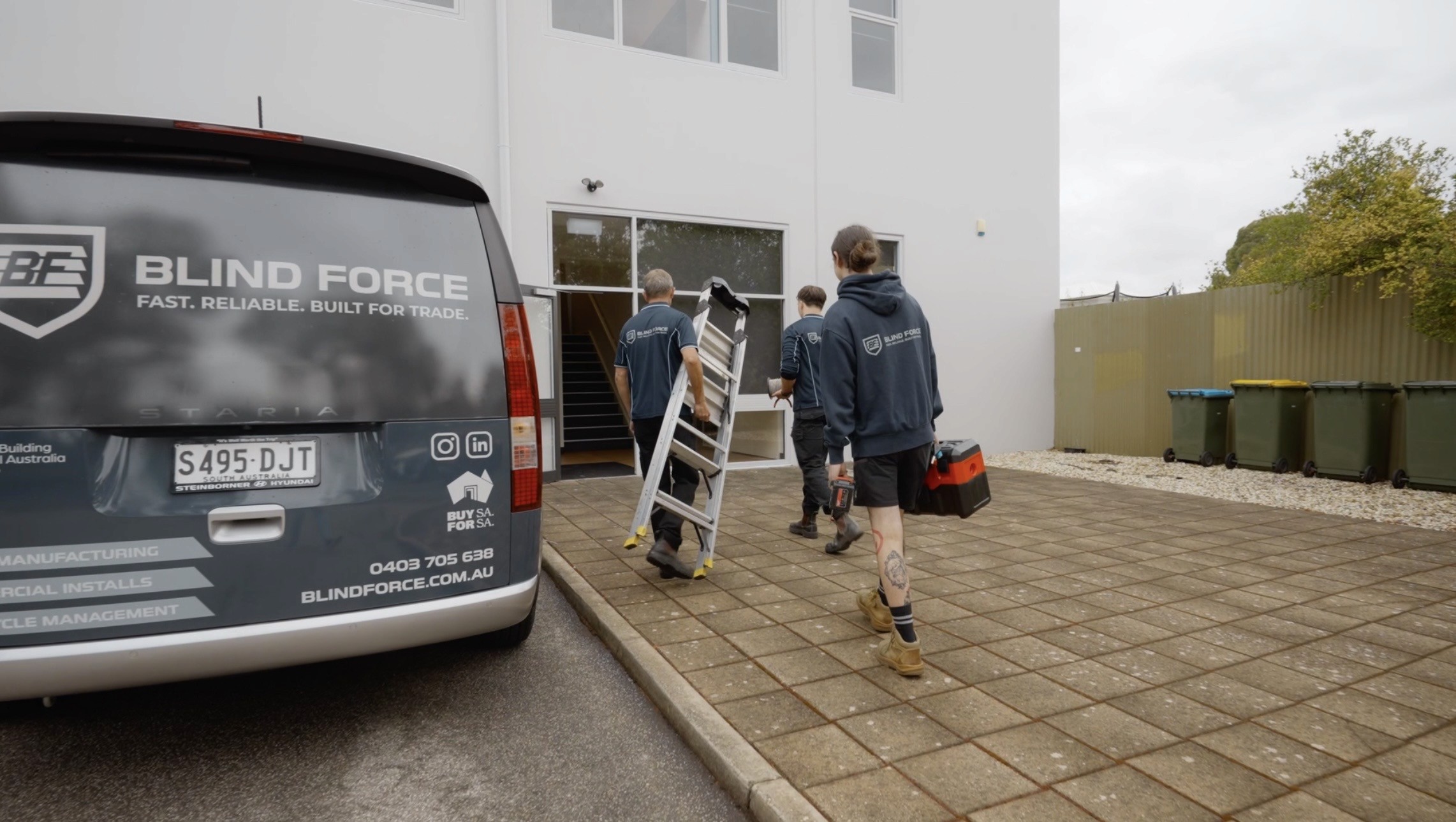 Install team walking to site with equipment ready for blind installation